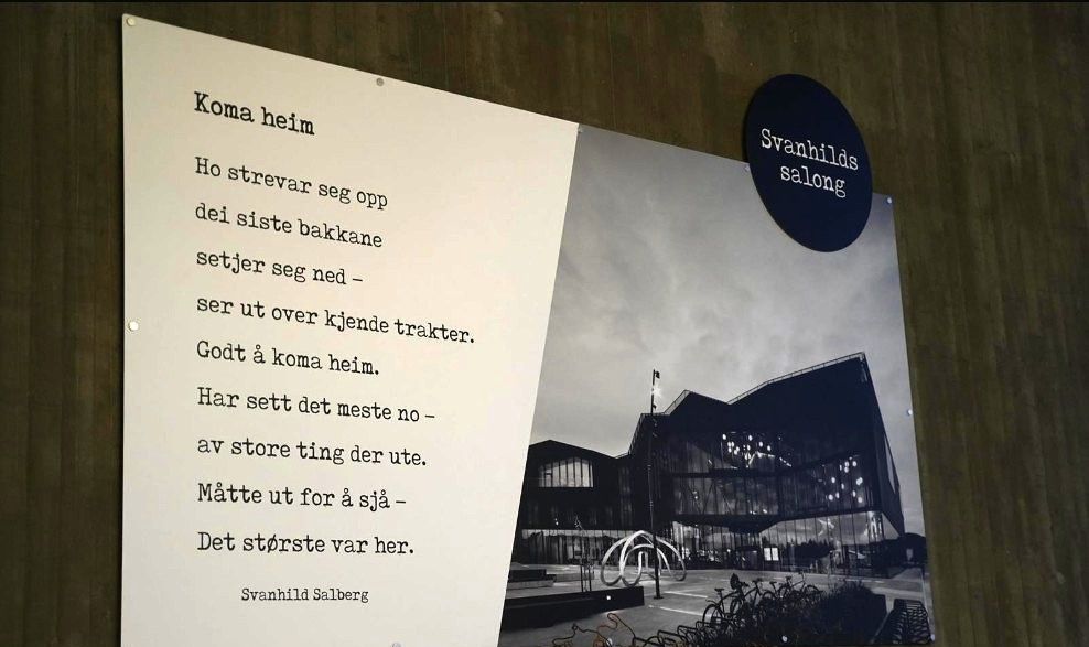 A poster on a wall shows a Norwegian poem next to a black and white photo of a modern building, with a circular "Svanhilds salong" sign above.
