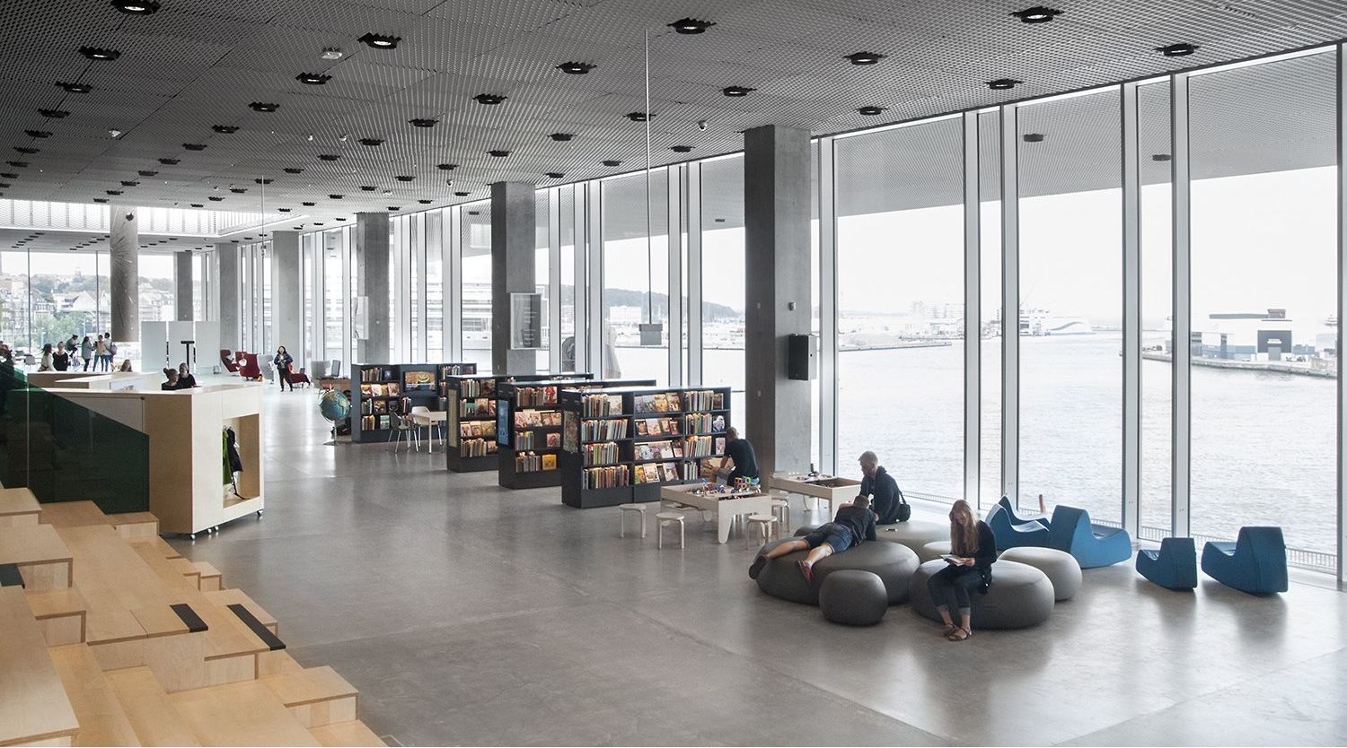 et bibliotekrom med veggpartier av glass fra topp til tå