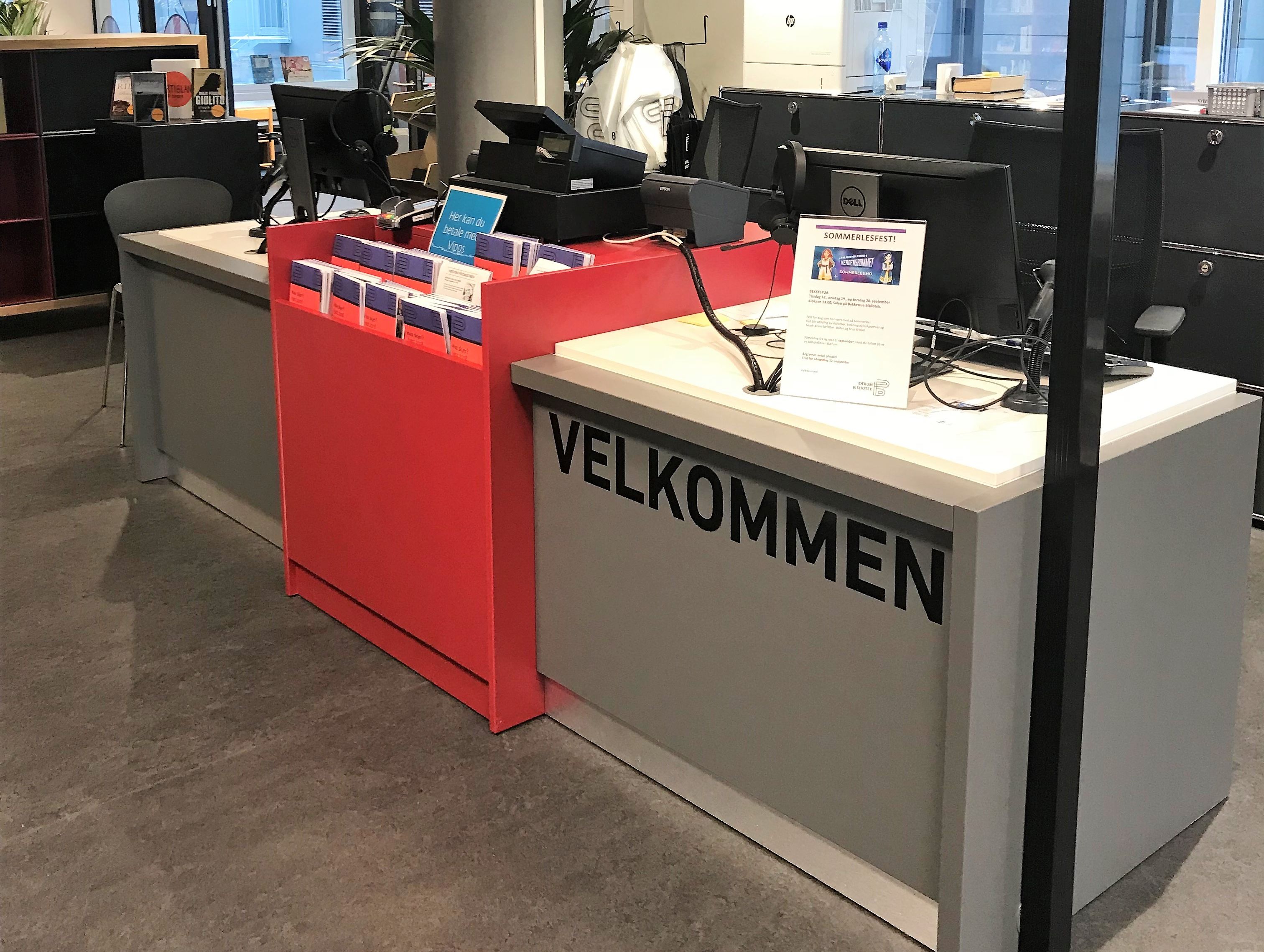 en grå bibliotekskranke med et rødt felt i midten for utstilling