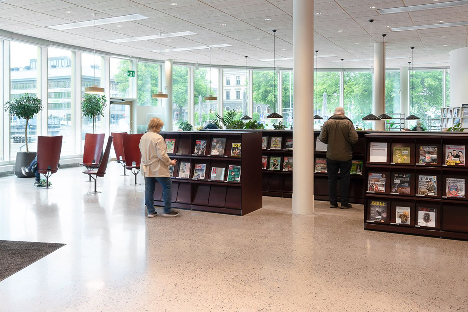 et bibliotek med mange bokreoler og mange store vinduer