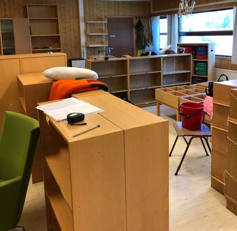 a room with lots of shelves and a chandelier hanging from the ceiling
