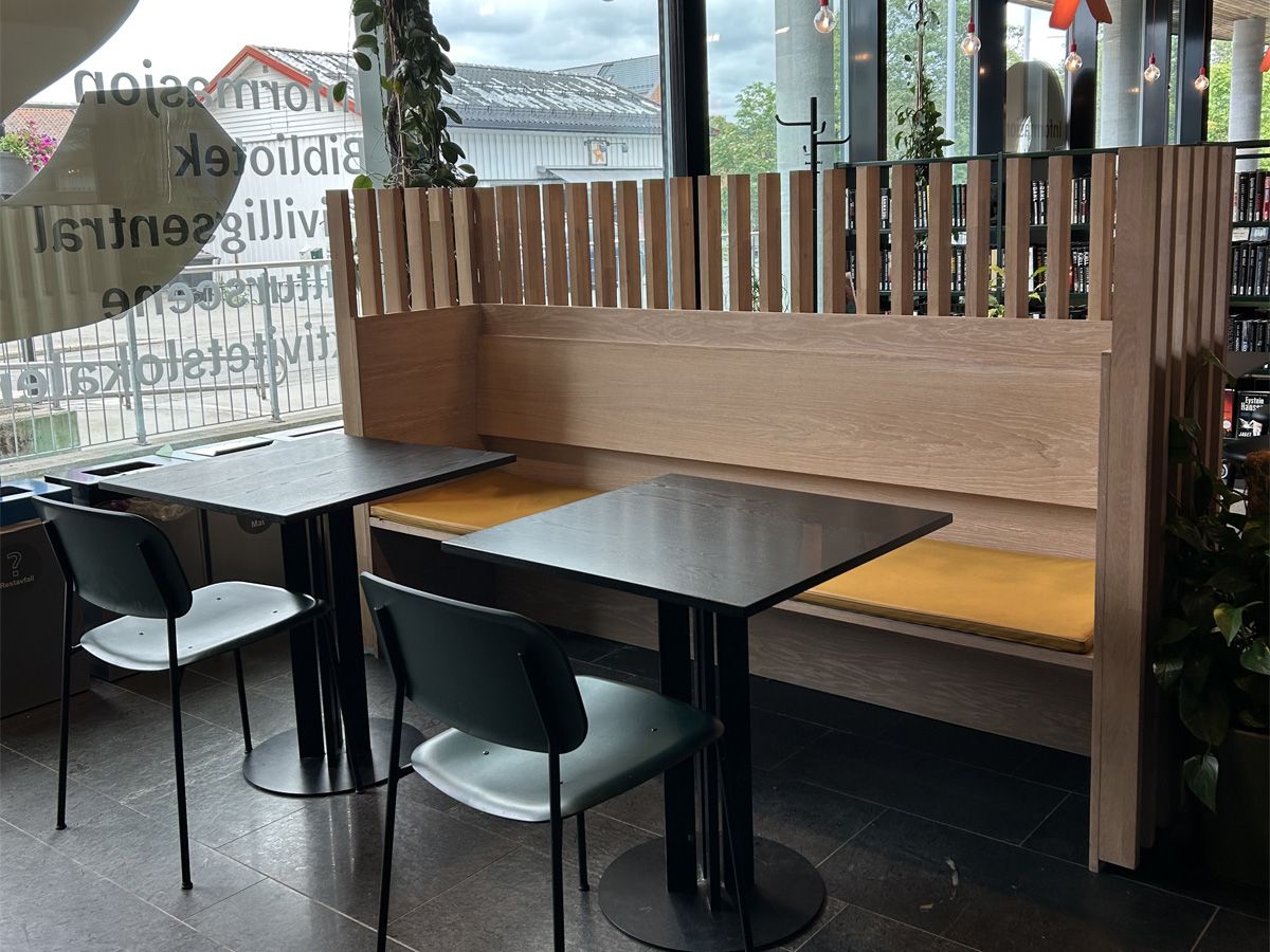 sitteplasser i et bibliotek med en bakvegg med spiler øverst