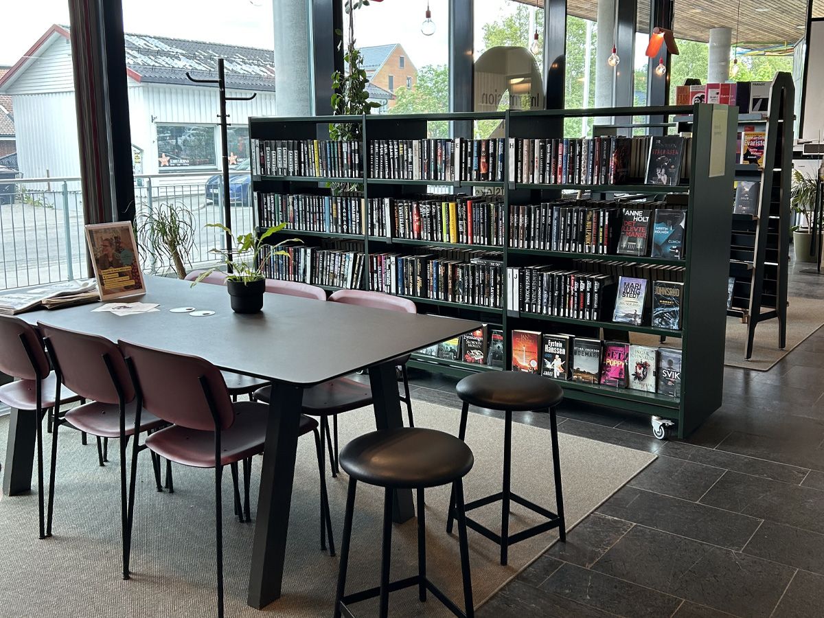 en sittegruppe på et bibliotek med en reol på hjul bak