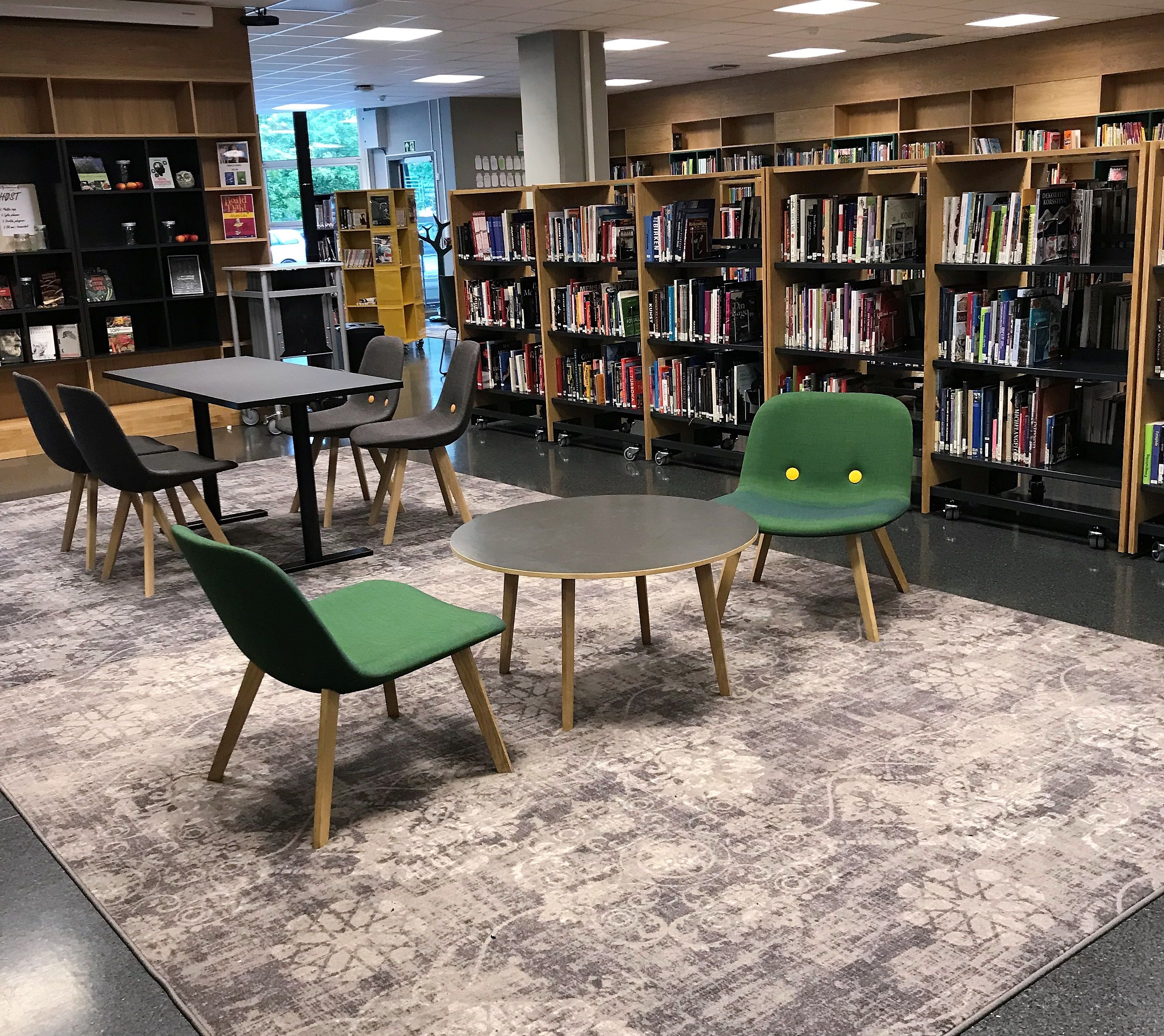 et bibliotek med bord og stoler og en projektor