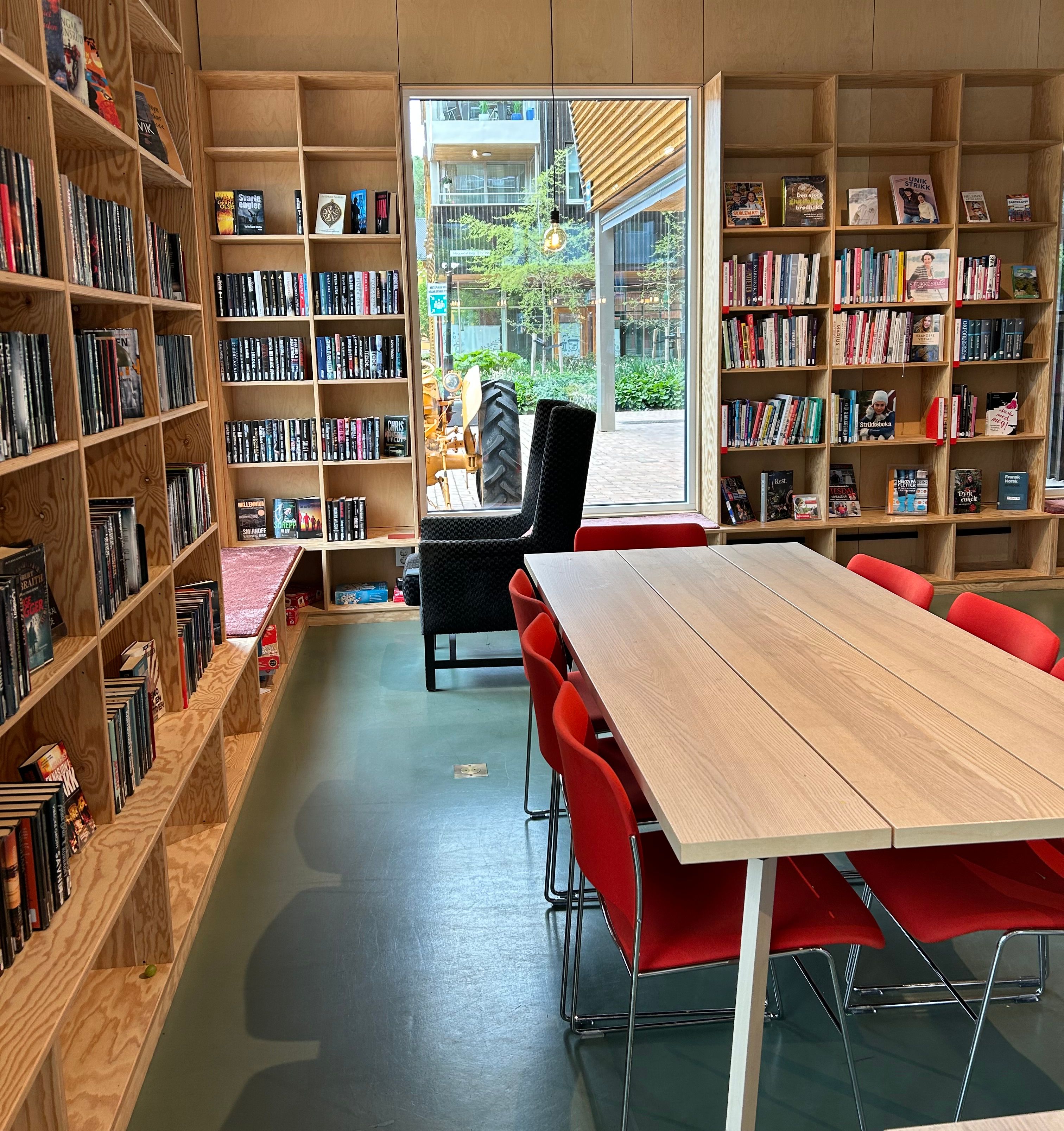 et bibliotek med et langt bord midt i rommet