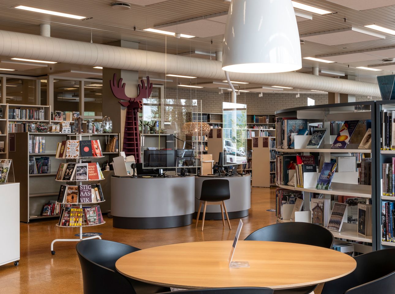 det er et bord og stoler i midten av biblioteket.