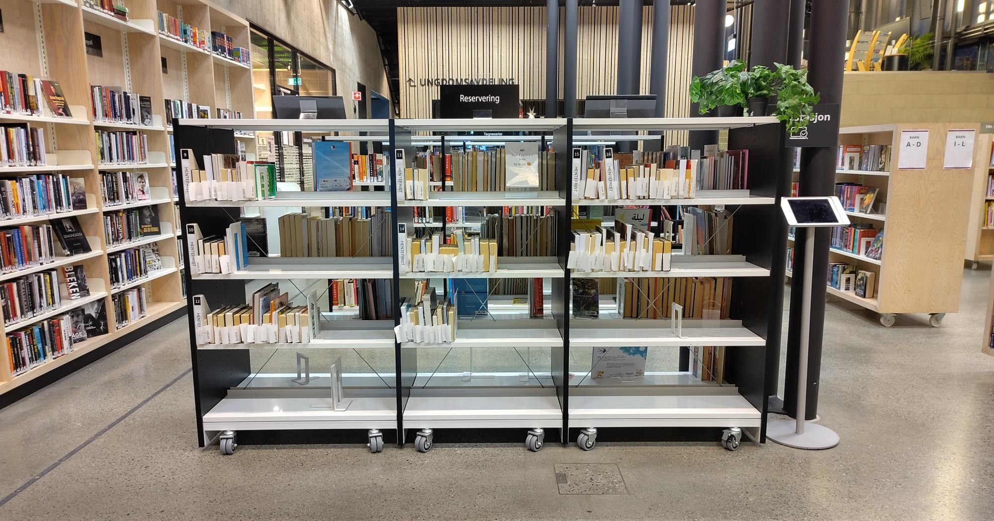 Three mobile bookshelves filled with books in a modern library.