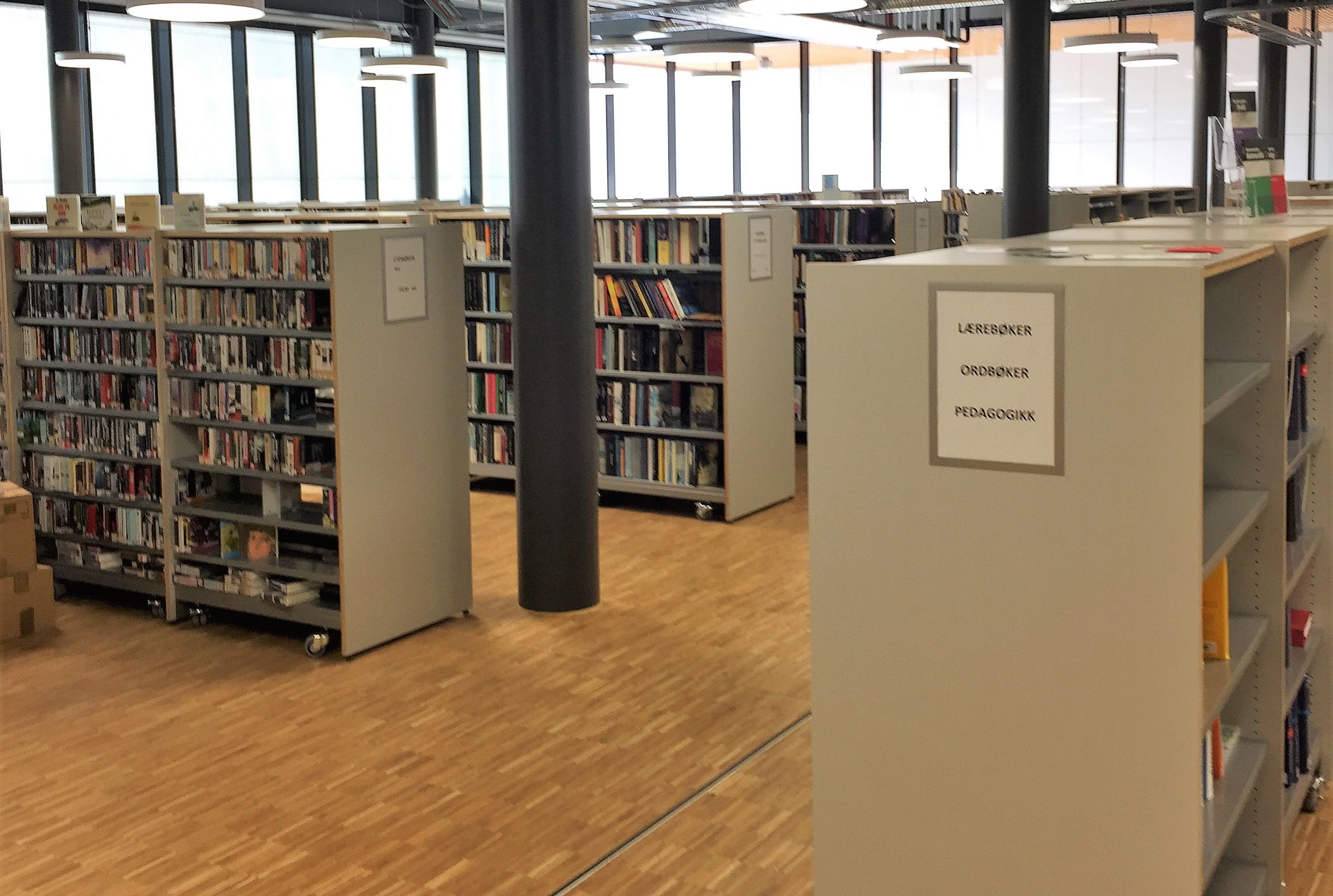et bibliotek med hyller fulle av bøker og et skilt som sier biblioteket