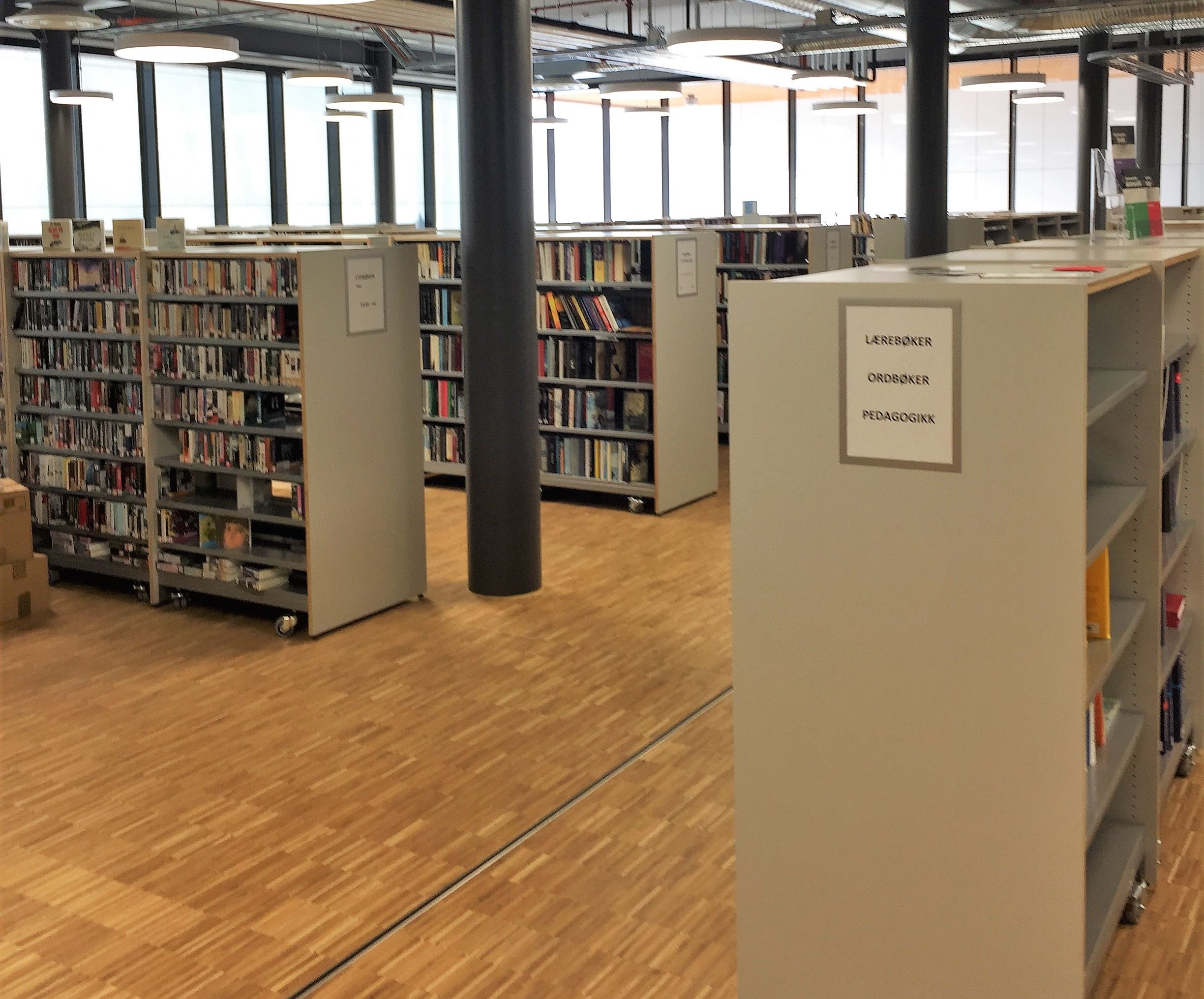 et bibliotek med hyller fulle av bøker og et skilt som sier biblioteket