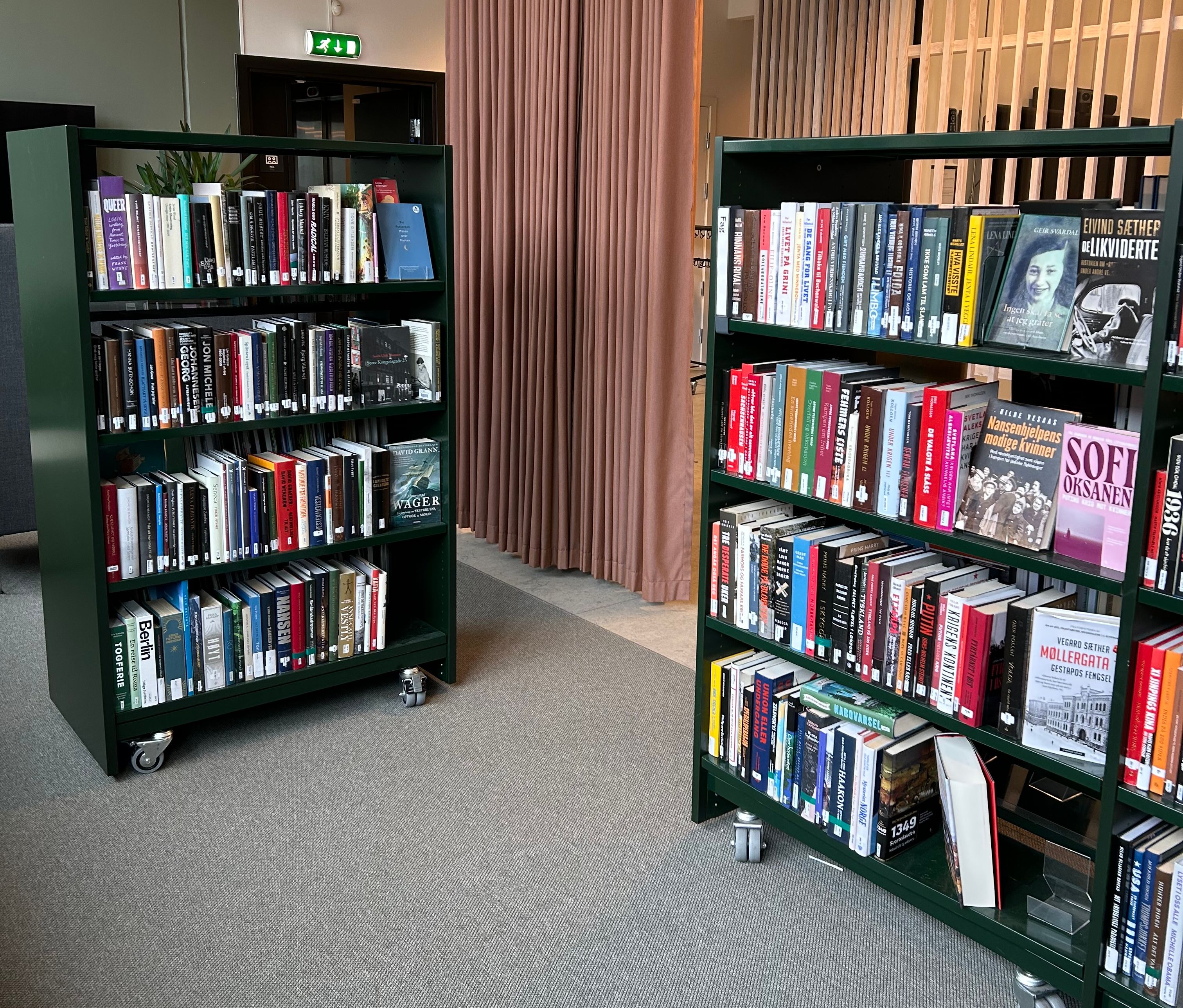 et bibliotek med fylte bokreoler på hjul