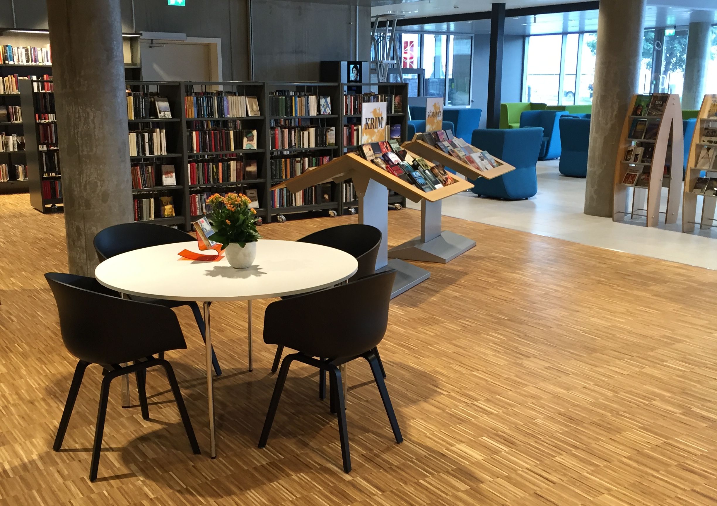 det er et bord og stoler i midten av et bibliotek.