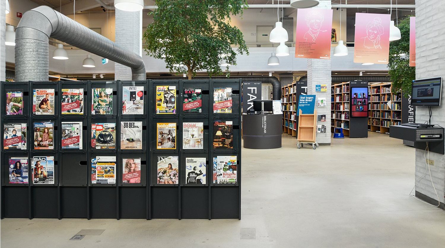 et bibliotek med mange bøker og magasiner til utstilling.