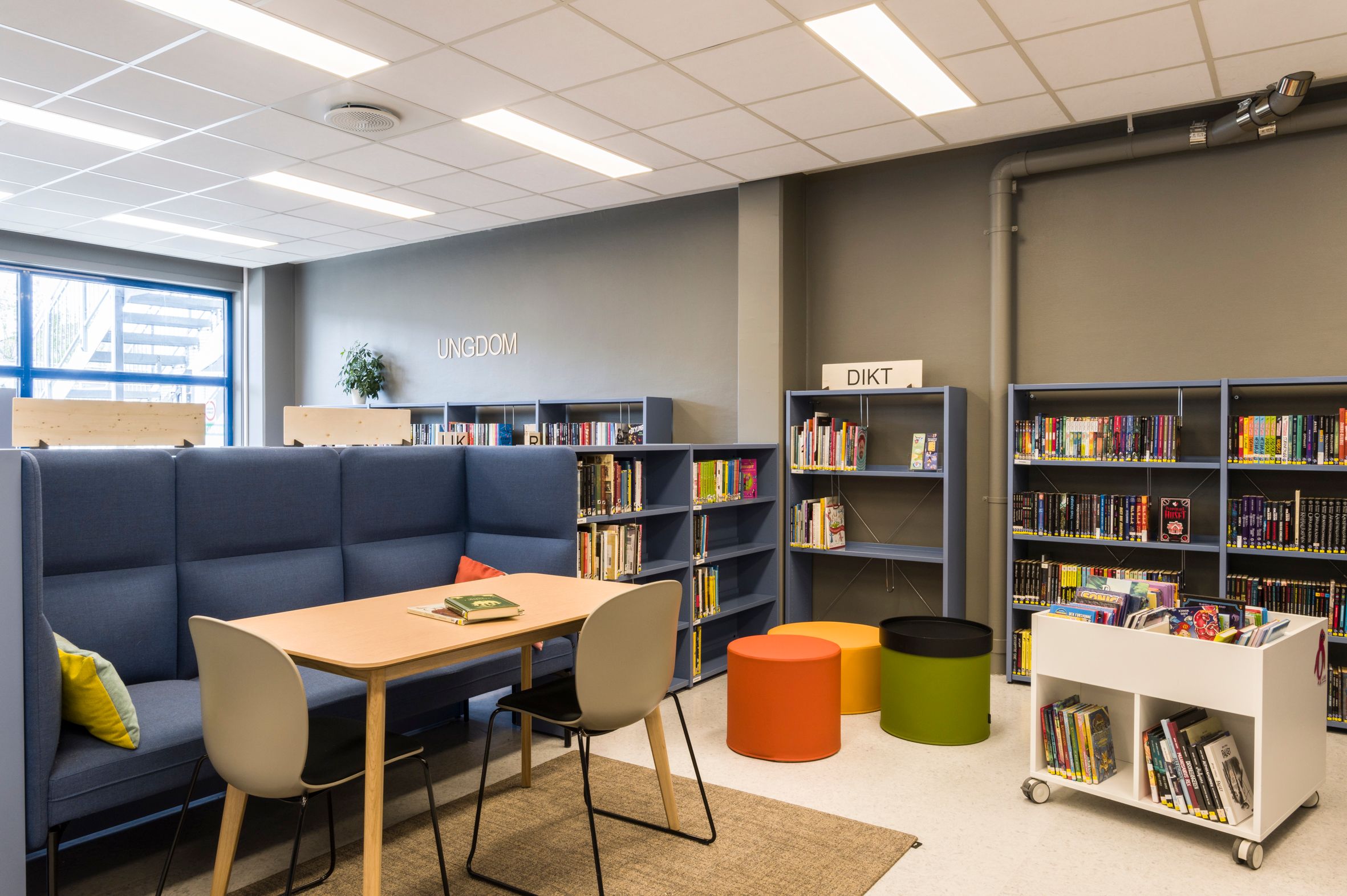 et bibliotek med mange bokreoler og sitteplasser