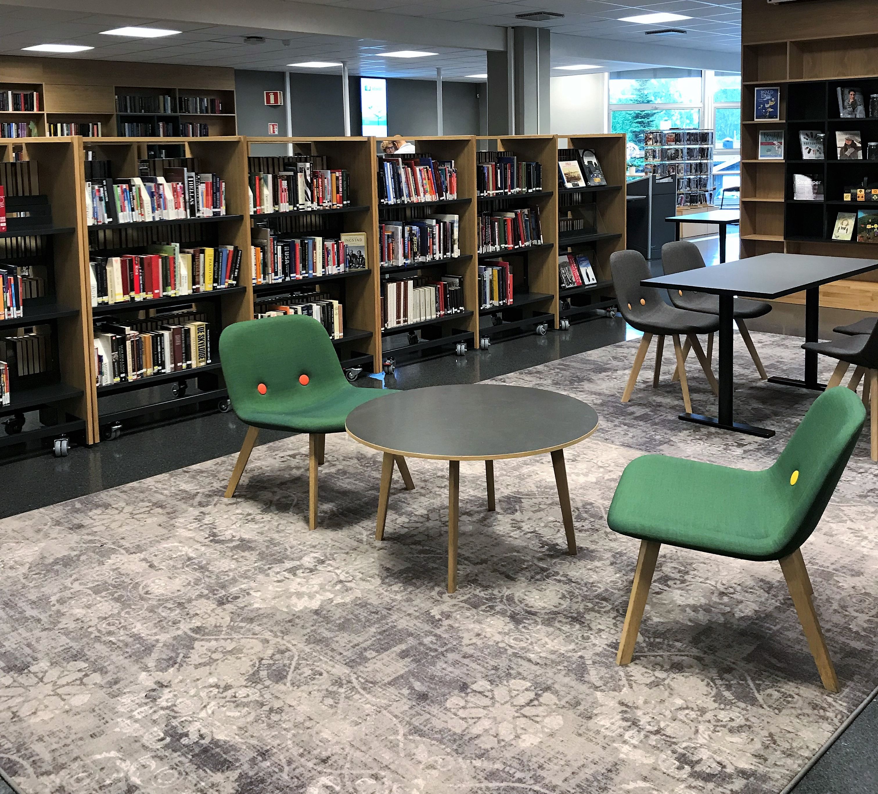 et bibliotek med bord og stoler og en projektor i taket
