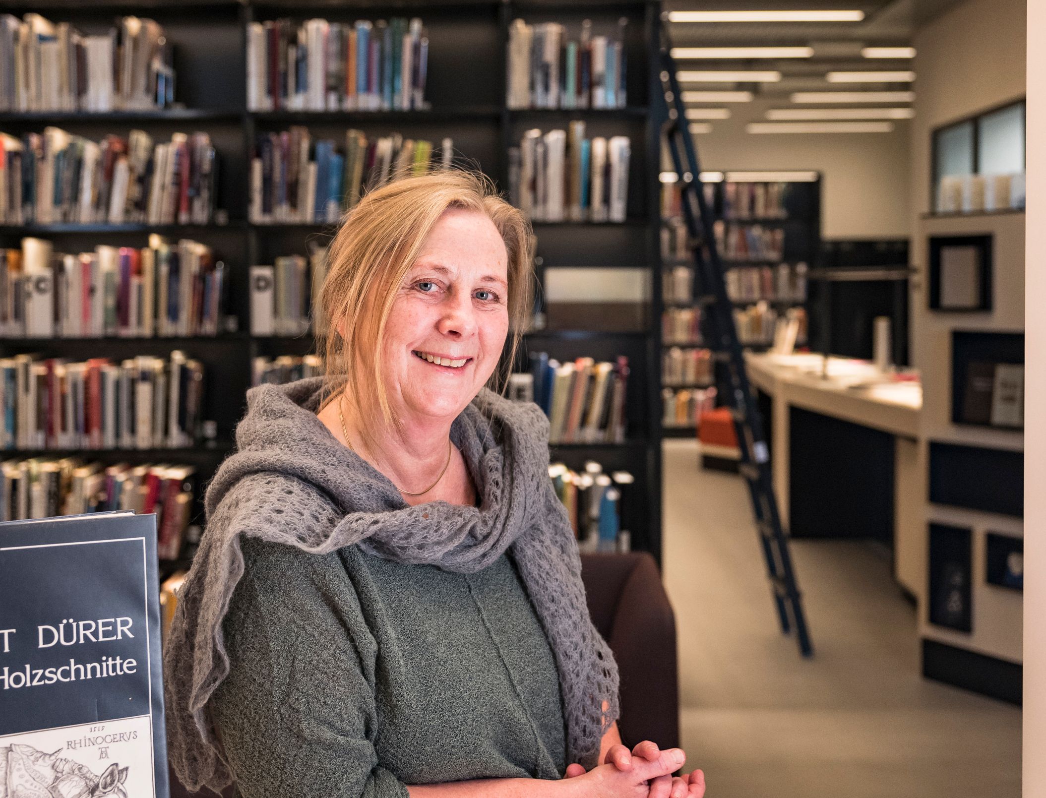en kvinne sitter ved et bord foran en bok med tittelen " t durer "