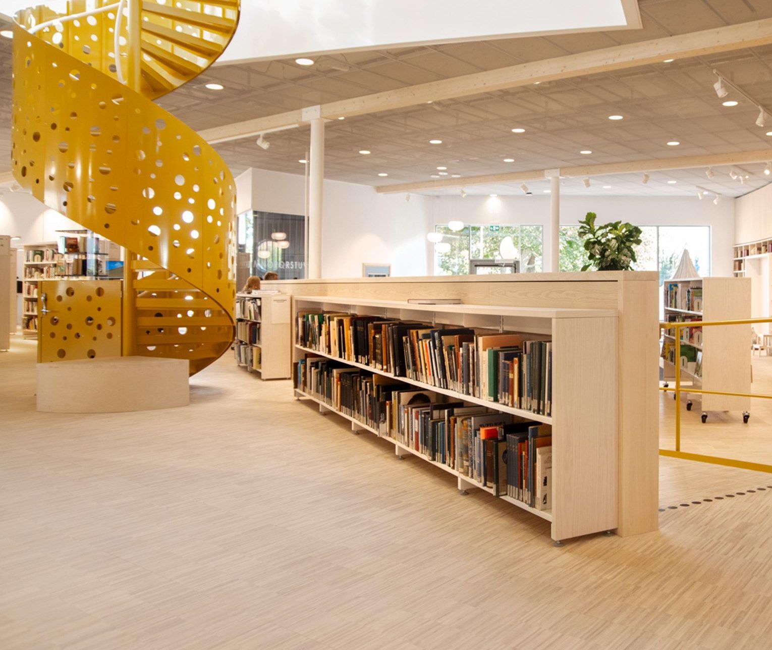 there is a spiral staircase in the middle of the library .