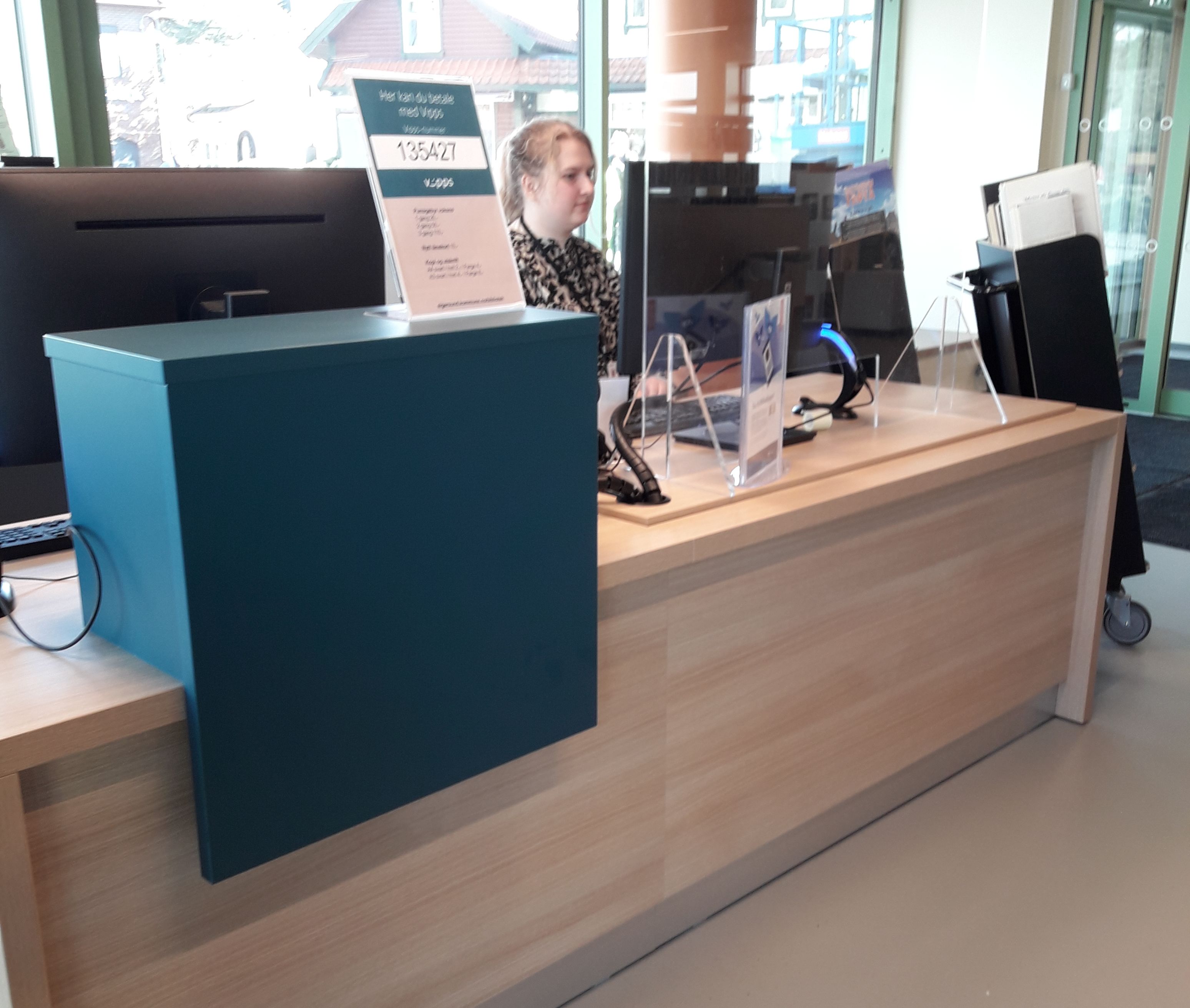 en dame sitter ved en bibliotekskranke i eik