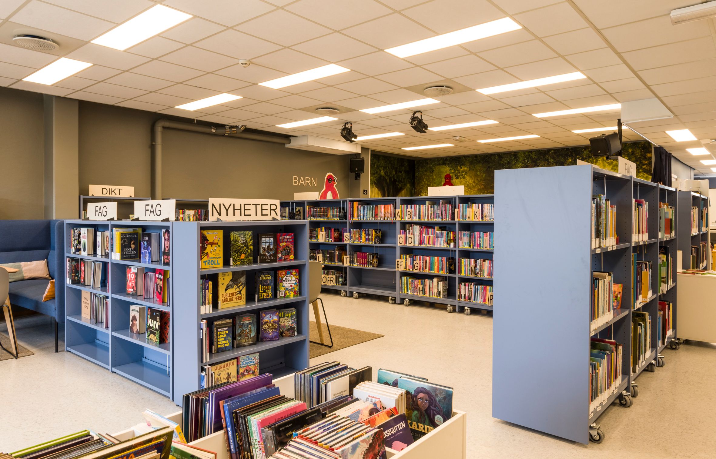 et bibliotek med mange bokreoler som står ute på gulvet