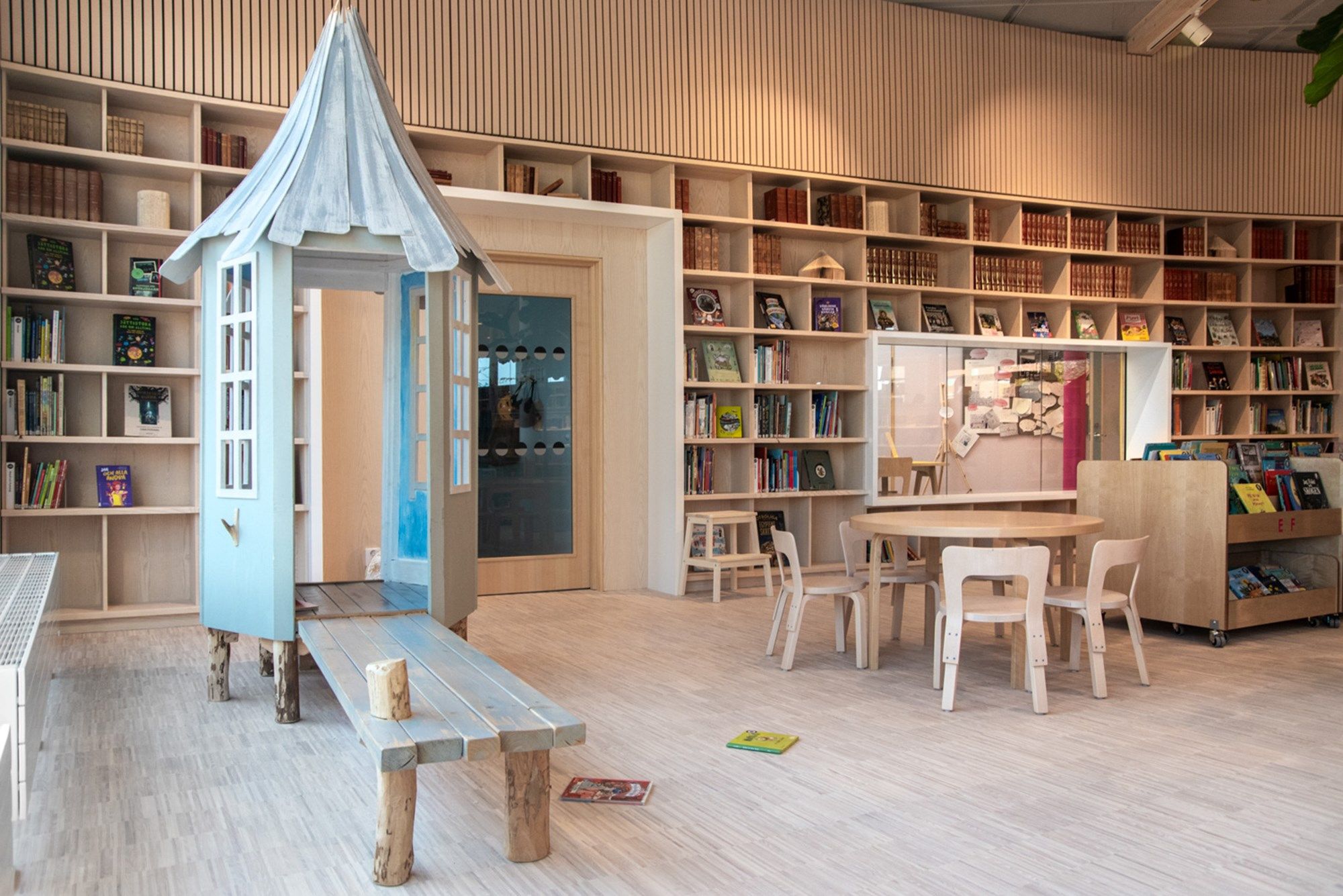 et bibliotek med bokreoler, og et lite hus som ligner på mummi-huset