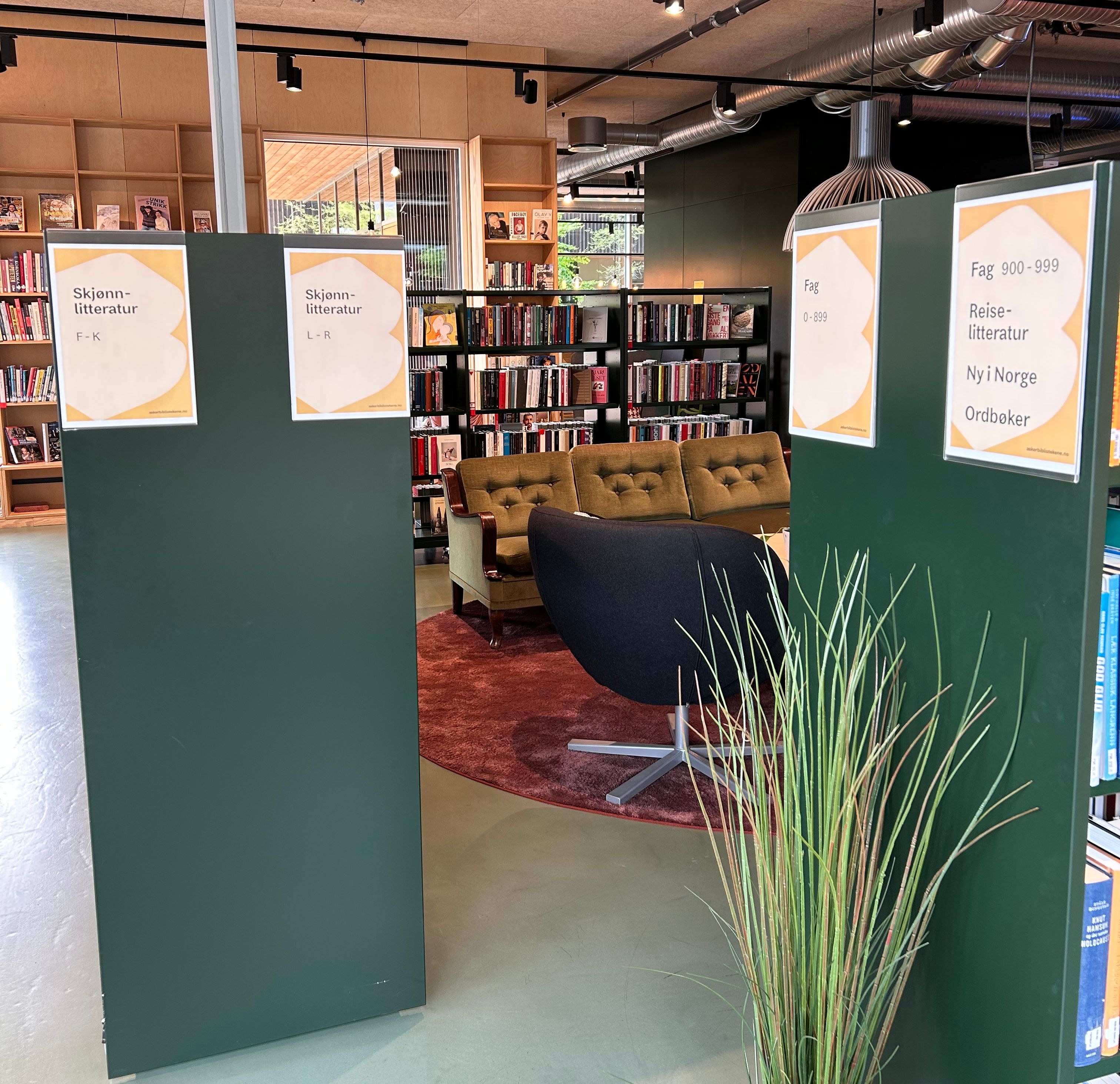 et bibliotek med flere bokreoler rundt en sitteplass