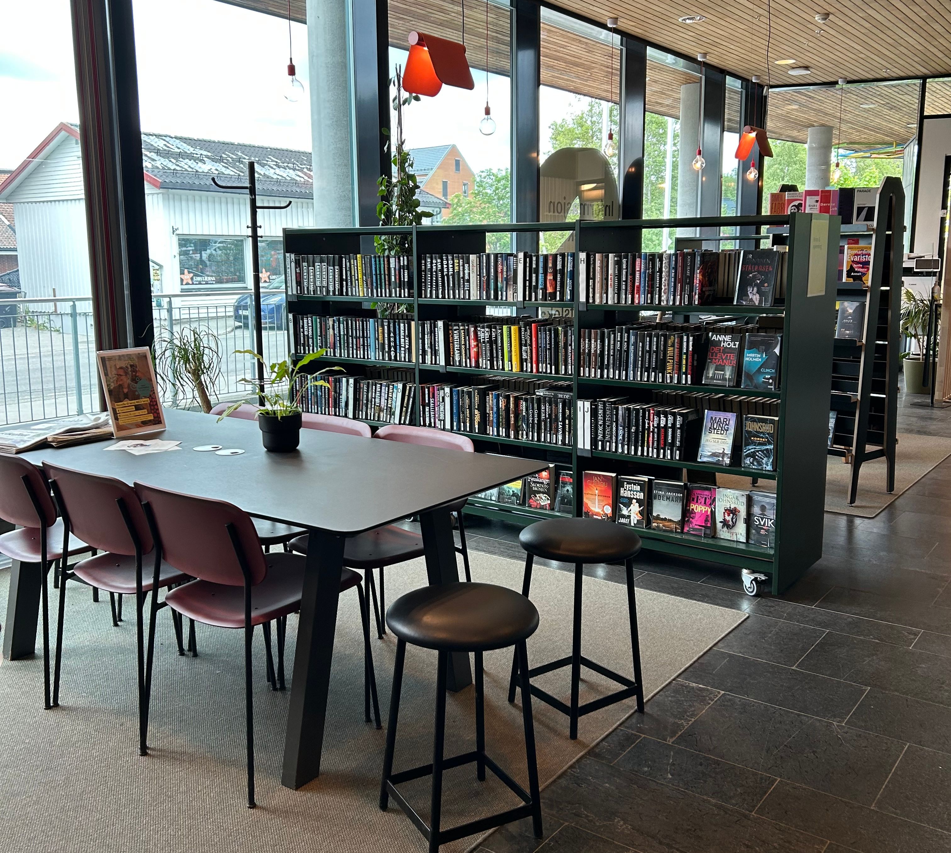 en sittegruppe på et bibliotek med en reol på hjul bak
