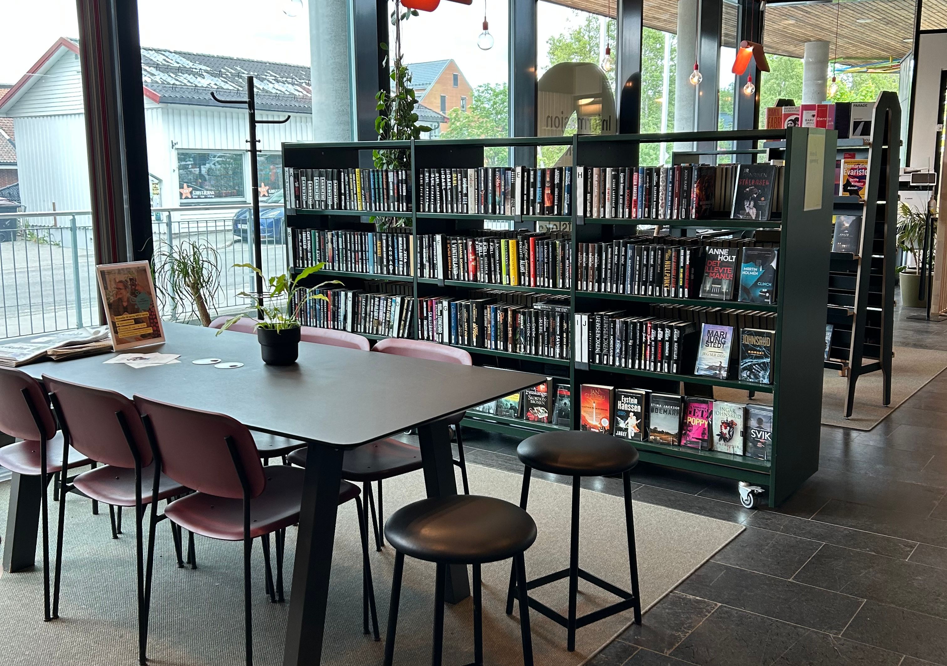 bord og stoler i et bibliotek med bokhyller fulle av bøker