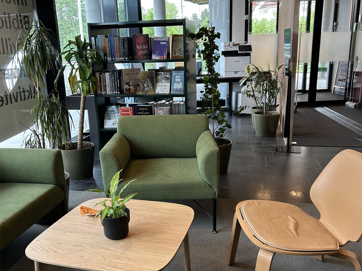 en grønn sittegruppe og en bokreol med mange bøker