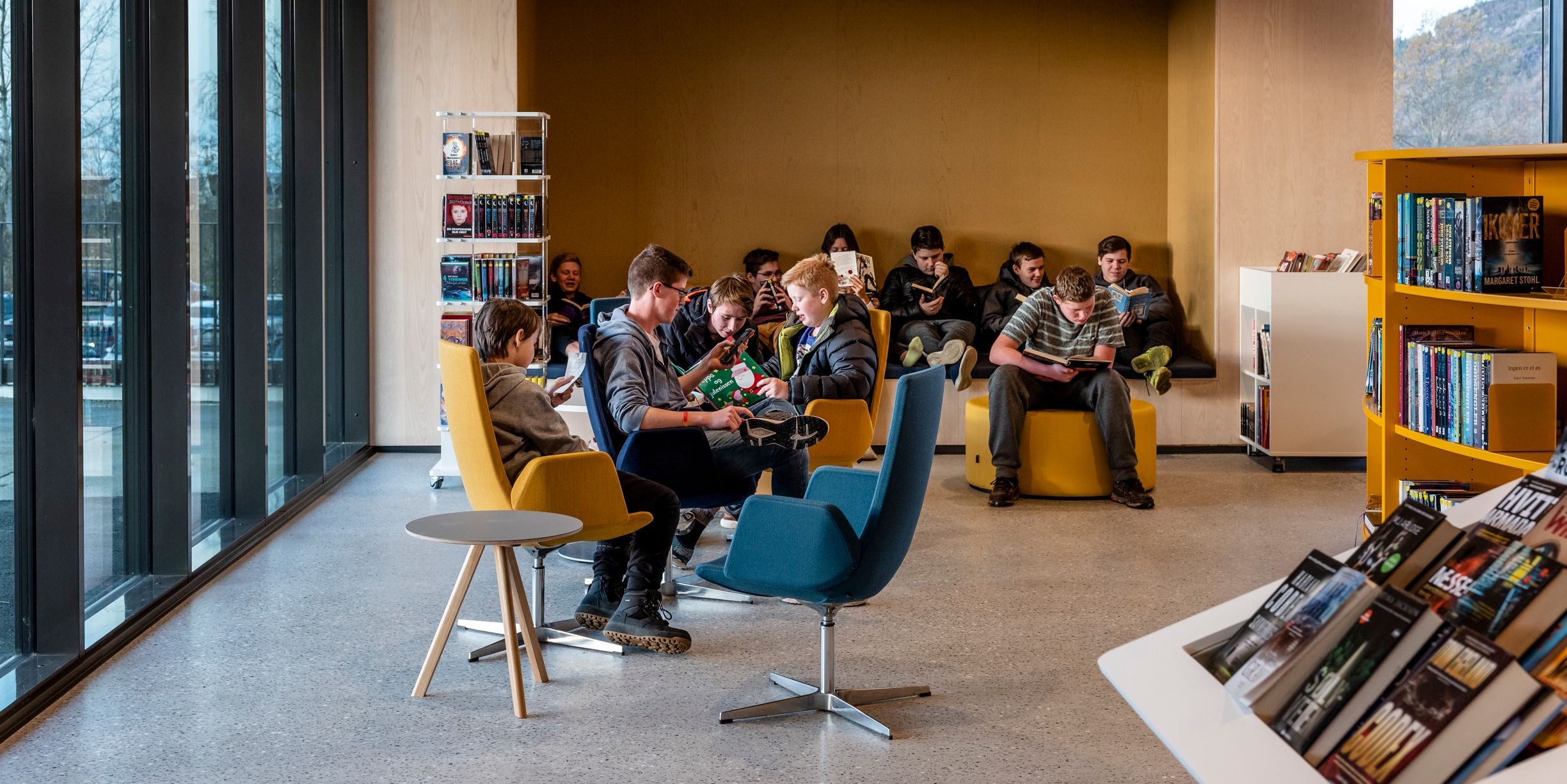 en gruppe mennesker sitter i stoler på et bibliotek.