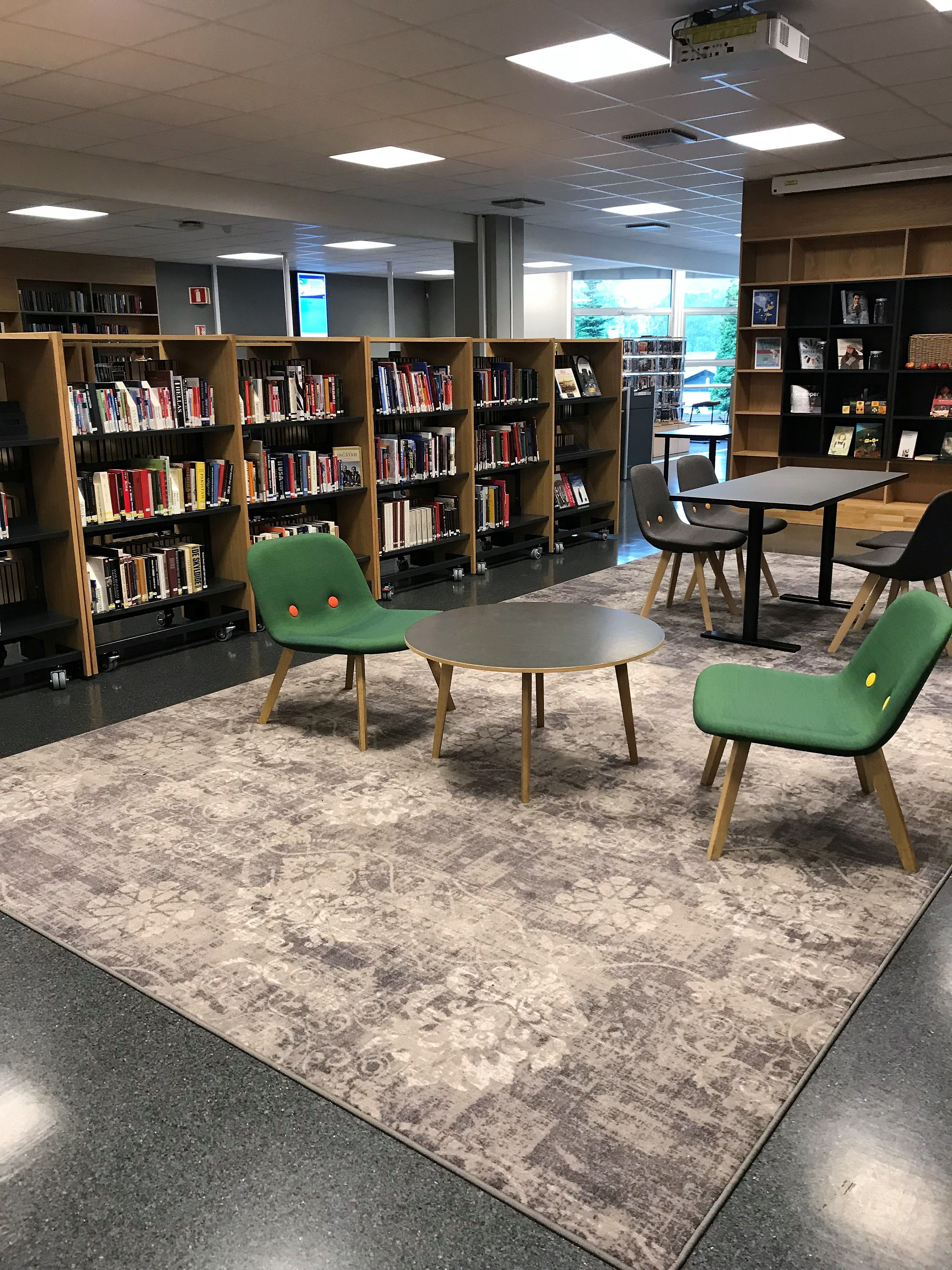 det er mange stoler og bord i biblioteket.