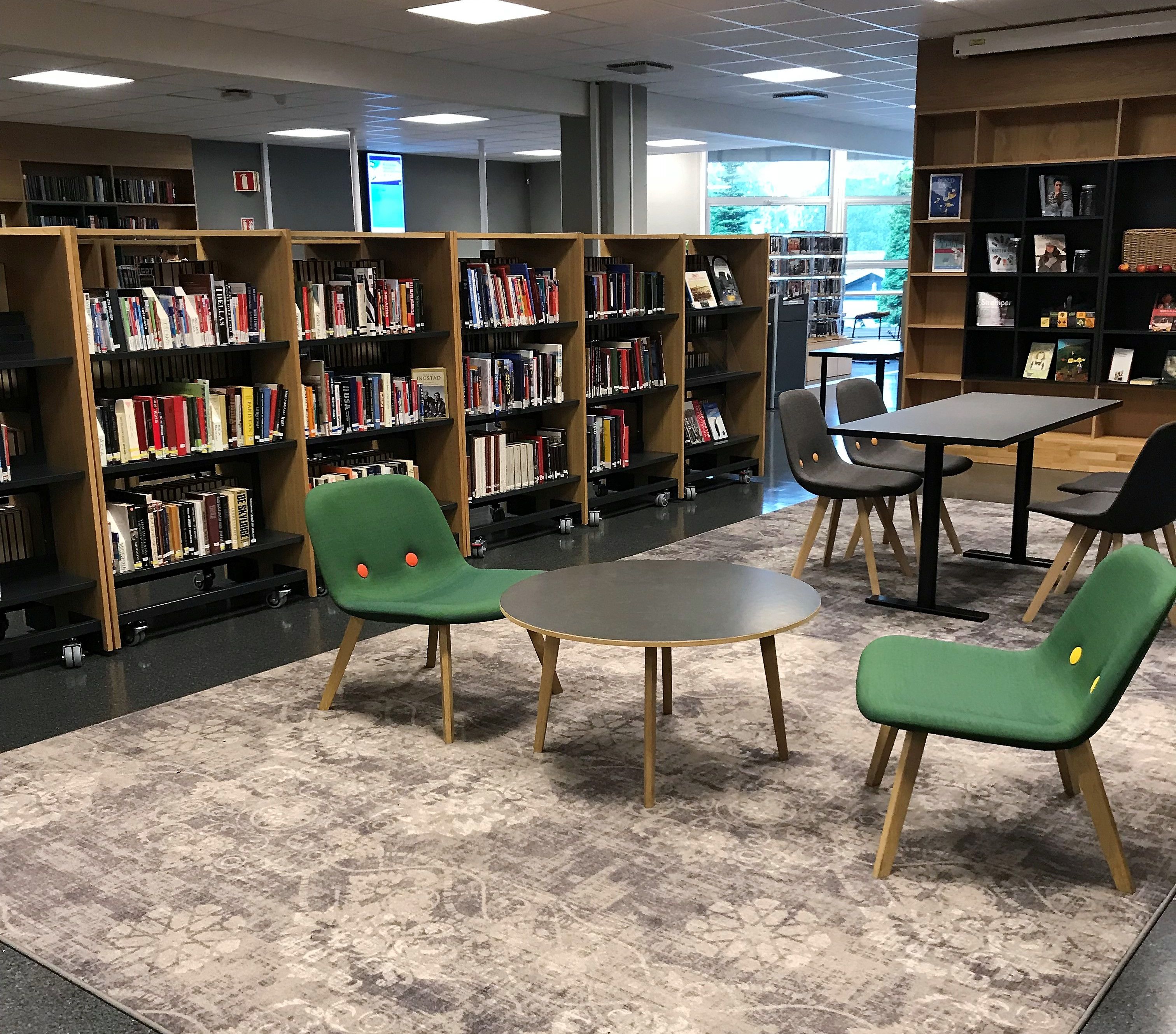 det er mange stoler og bord i biblioteket.