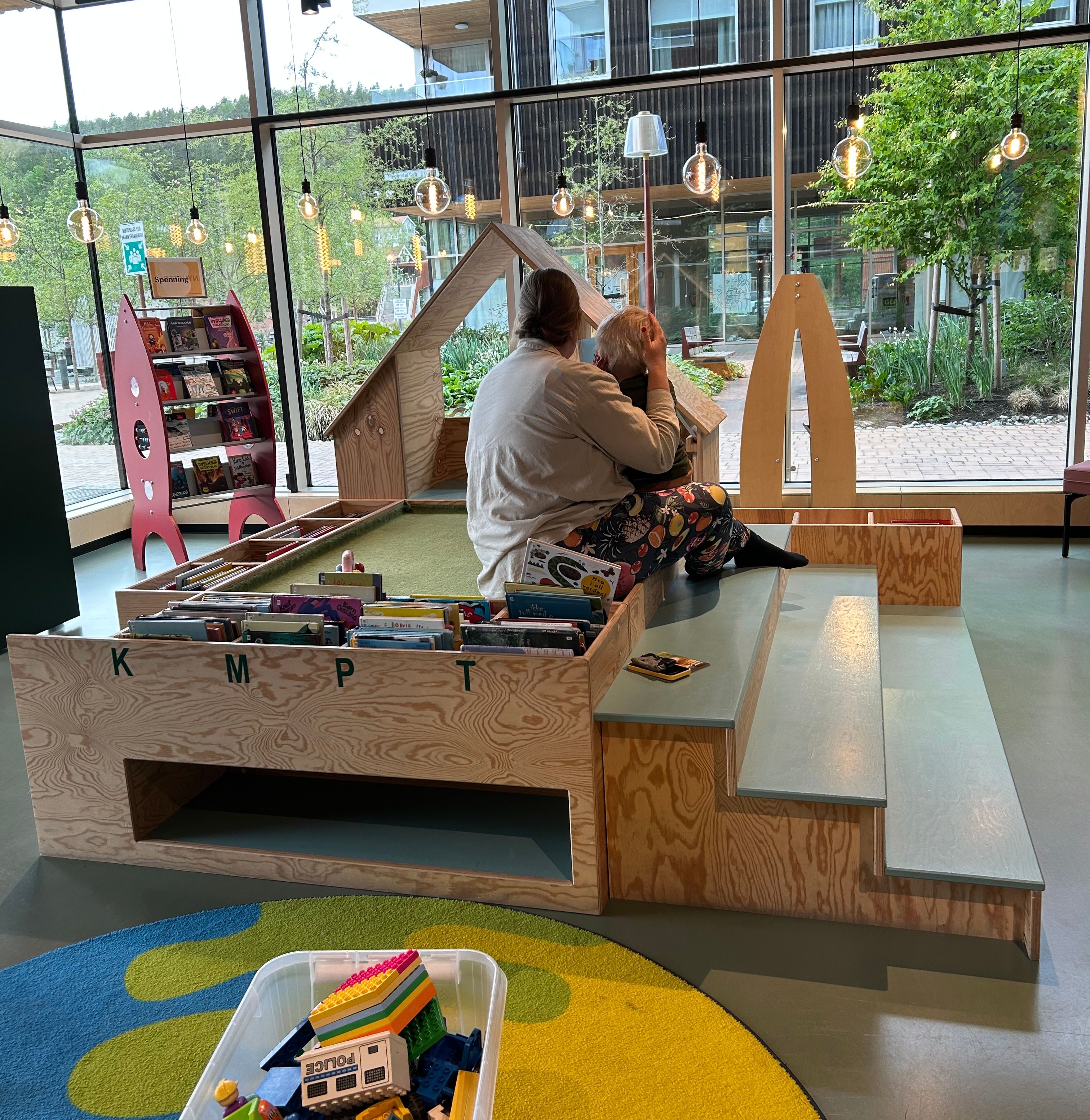 en liten tribune av sponplate midt i et bibliotek