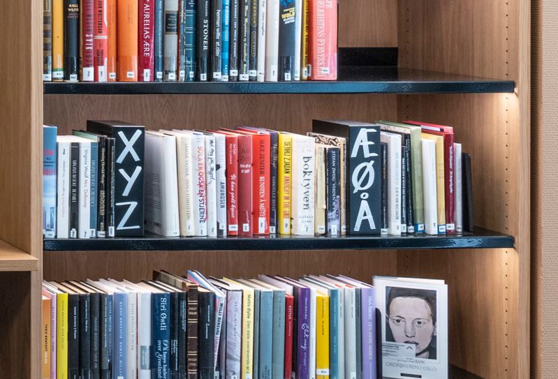 et bibliotek med en benk og hyller fylt med bøker.