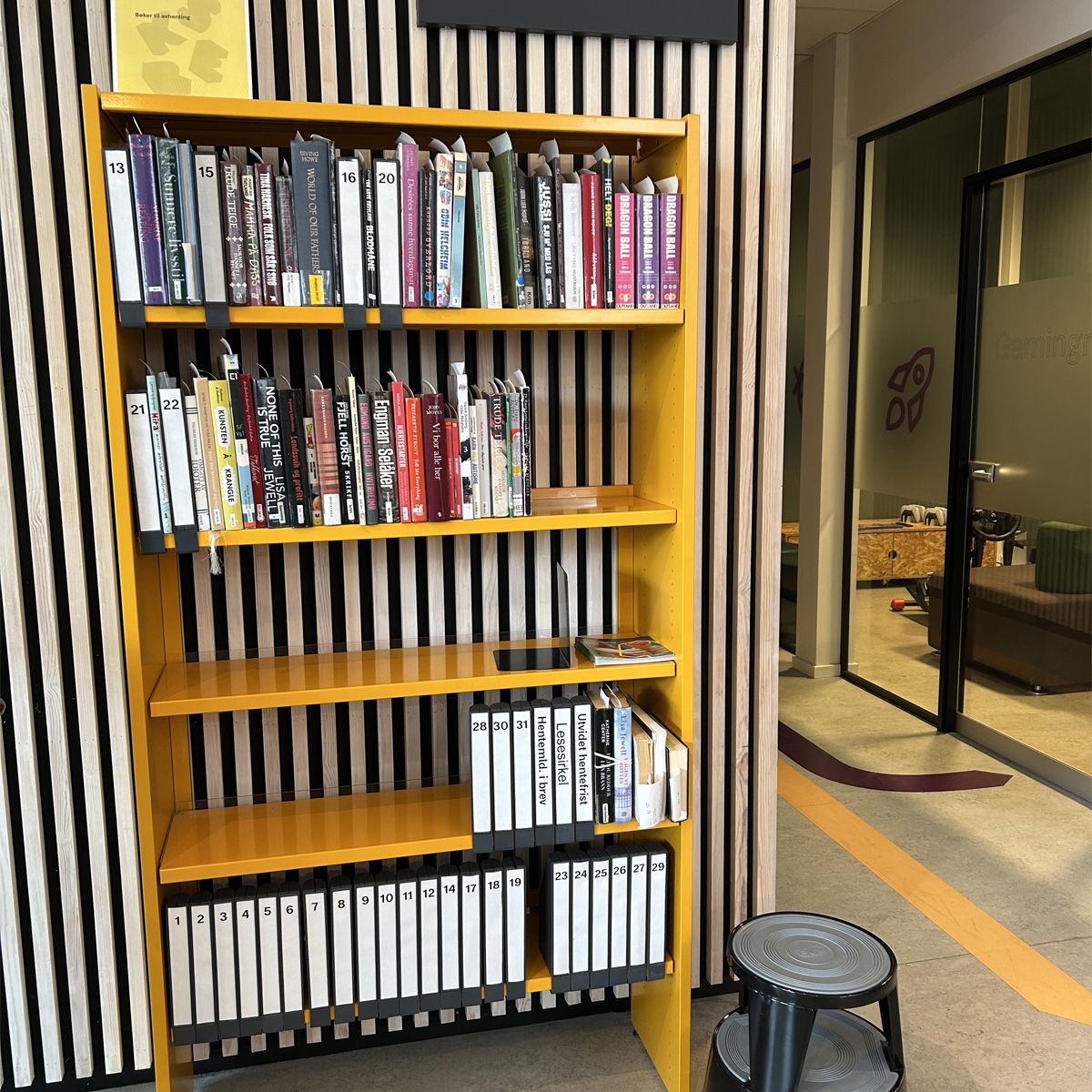 en gul bokreol er plassert foran en spilevegg