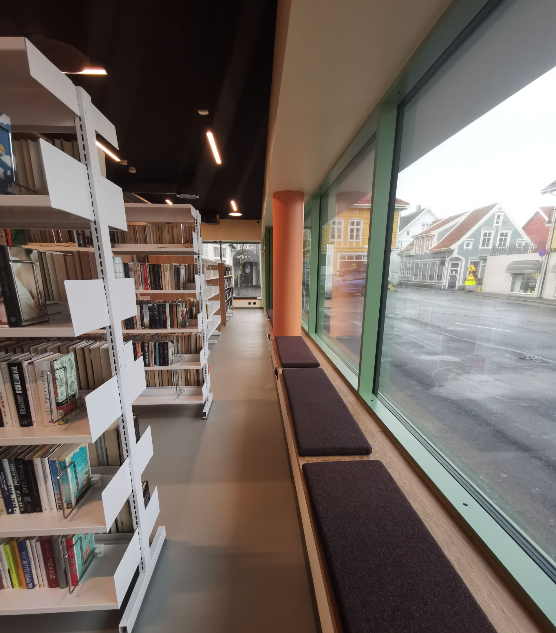 en rad med bokhyller i et bibliotek med et vindu