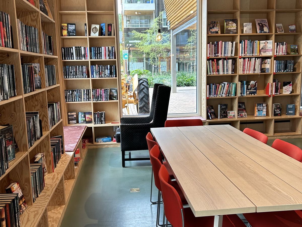 et bibliotek med flere bokreoler rundt en sitteplass