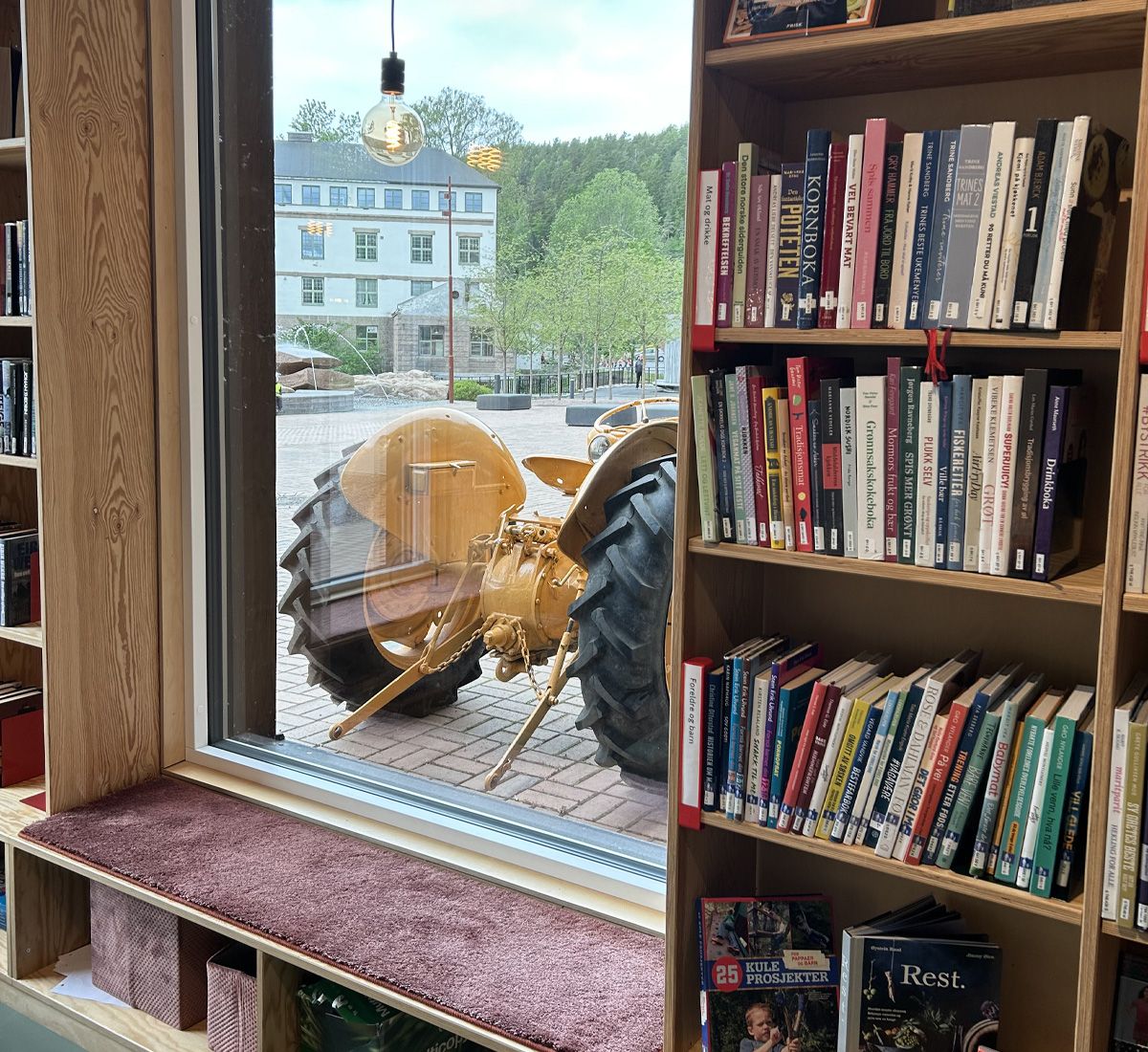 et bibliotek med en gul traktor parkert utenfor vinduet