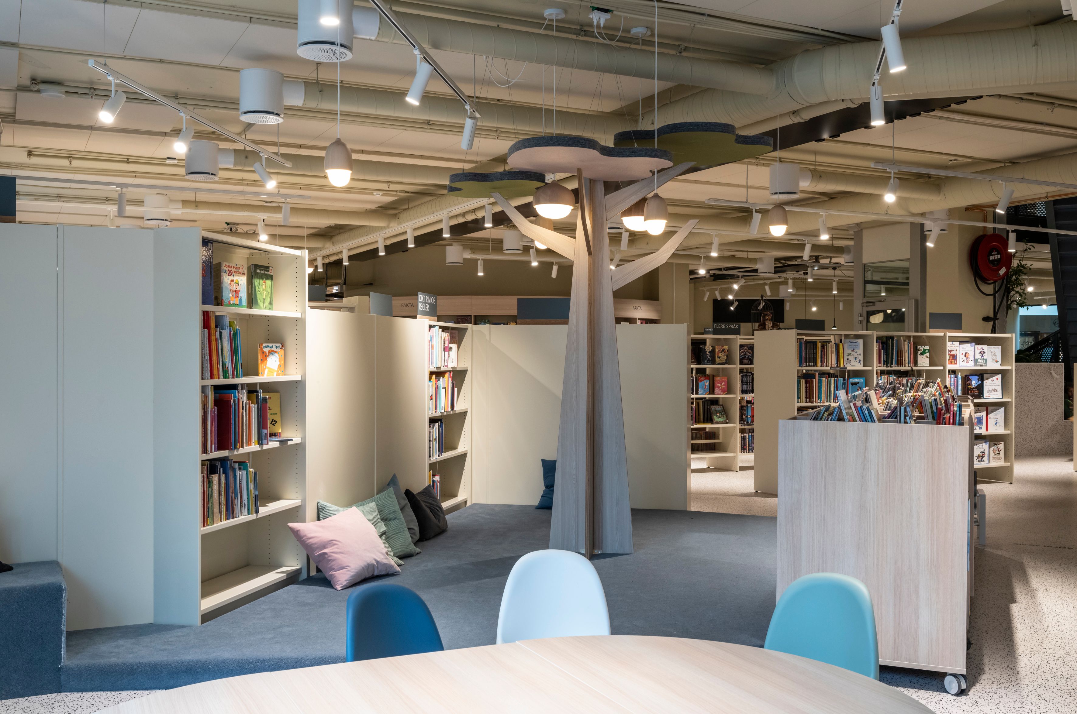 det er et bord og stoler i midten av biblioteket.