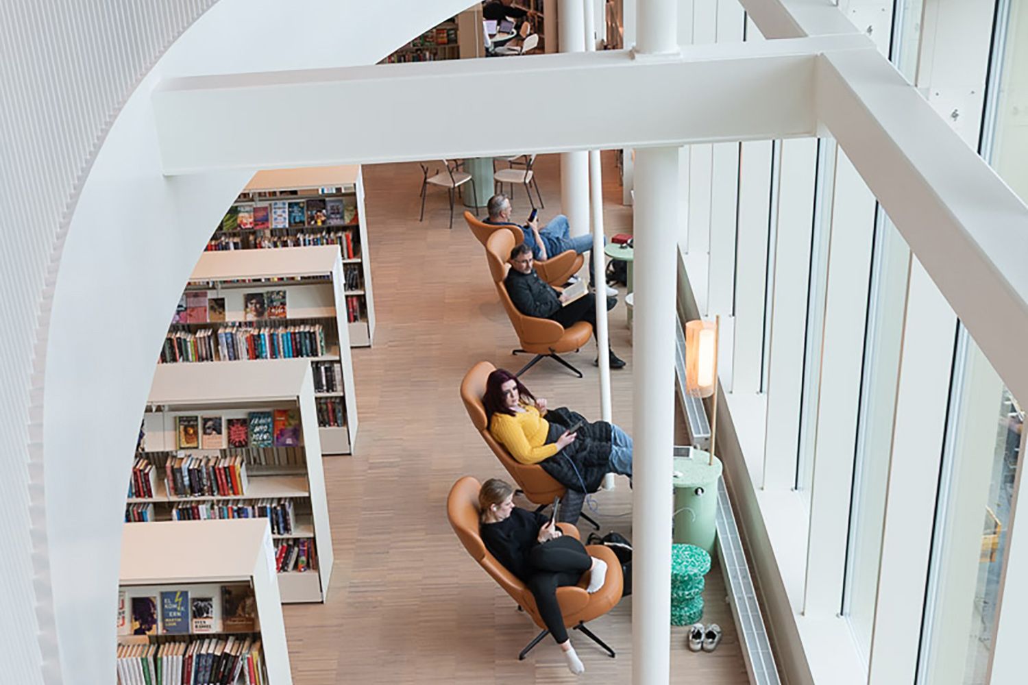 et bibliotek med mange lenestoler og bokreoler