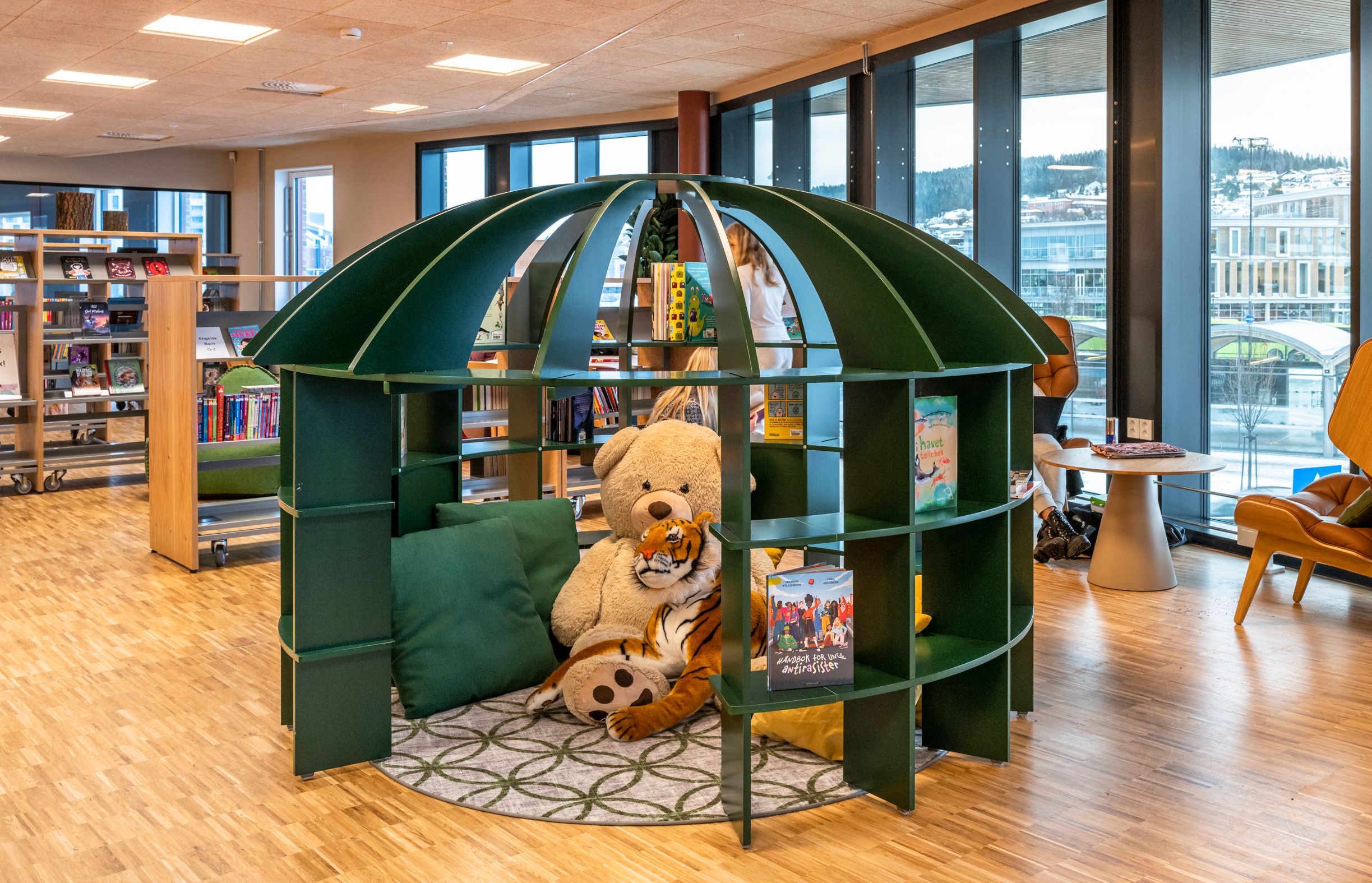 en teddybjørn sitter i en lesekrok i et bibliotek.