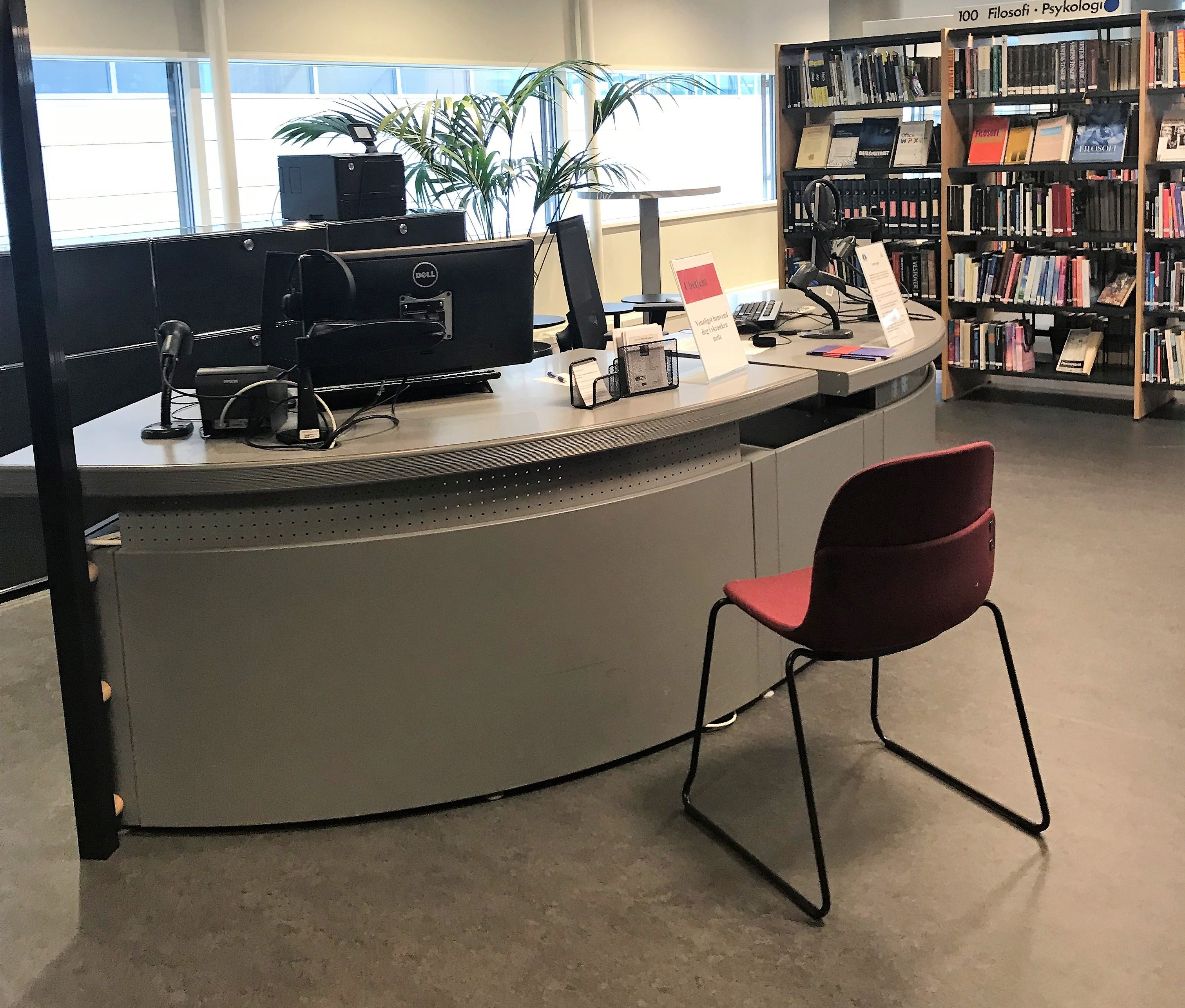 en dell-datamaskin sitter på et skrivebord i et bibliotek