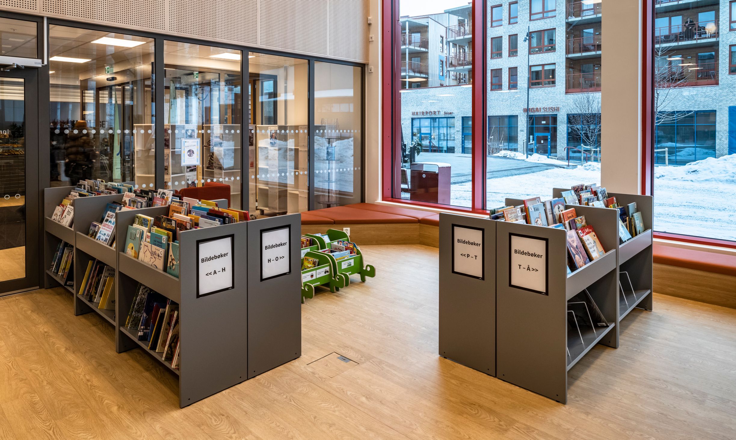 et bibliotek med mange bøker på hyllene og et stort vindu.
