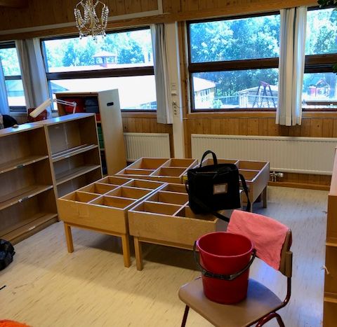 a red bucket sits on a chair in an empty room