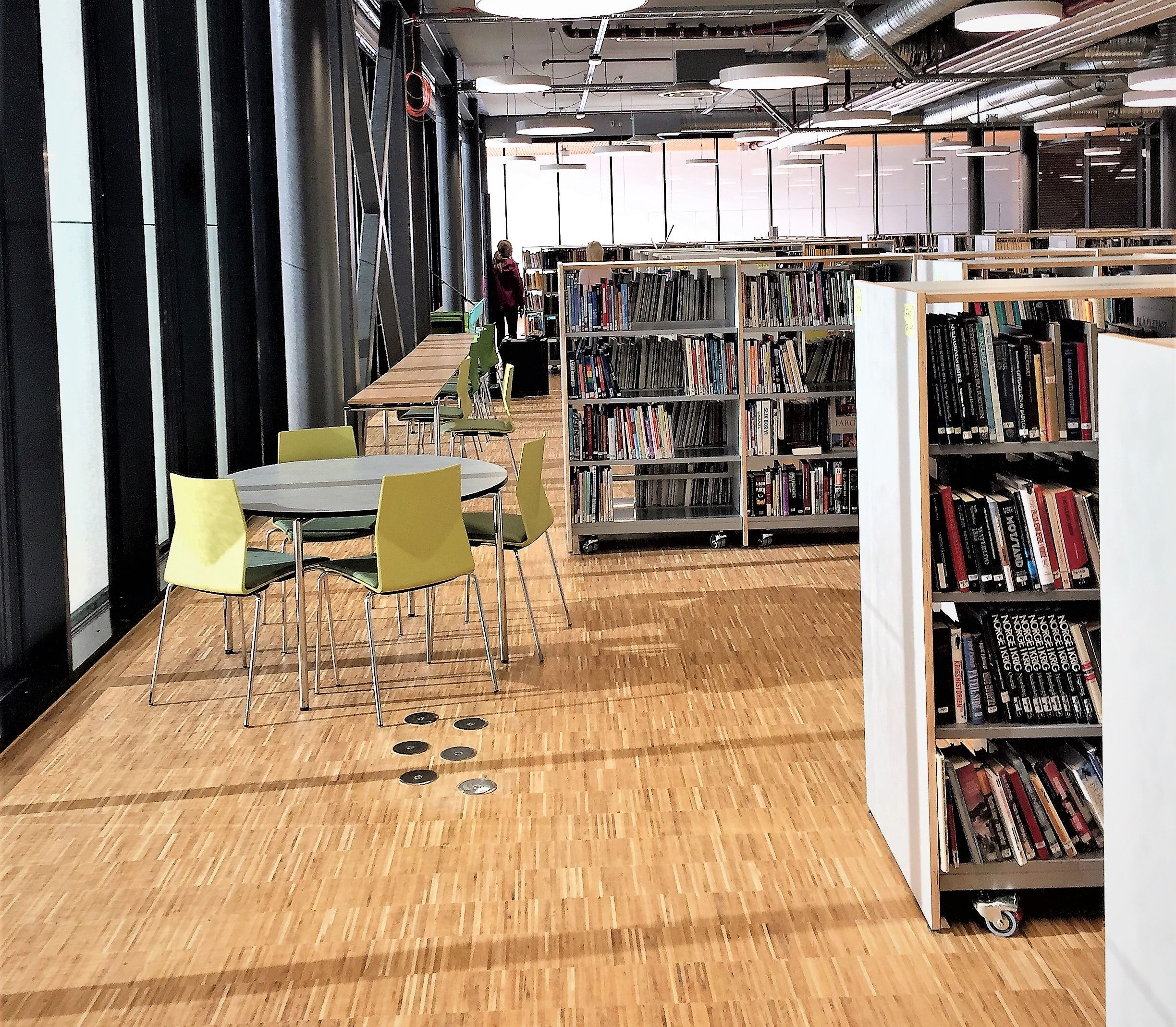 et bibliotek fylt med bøker og bord og stoler