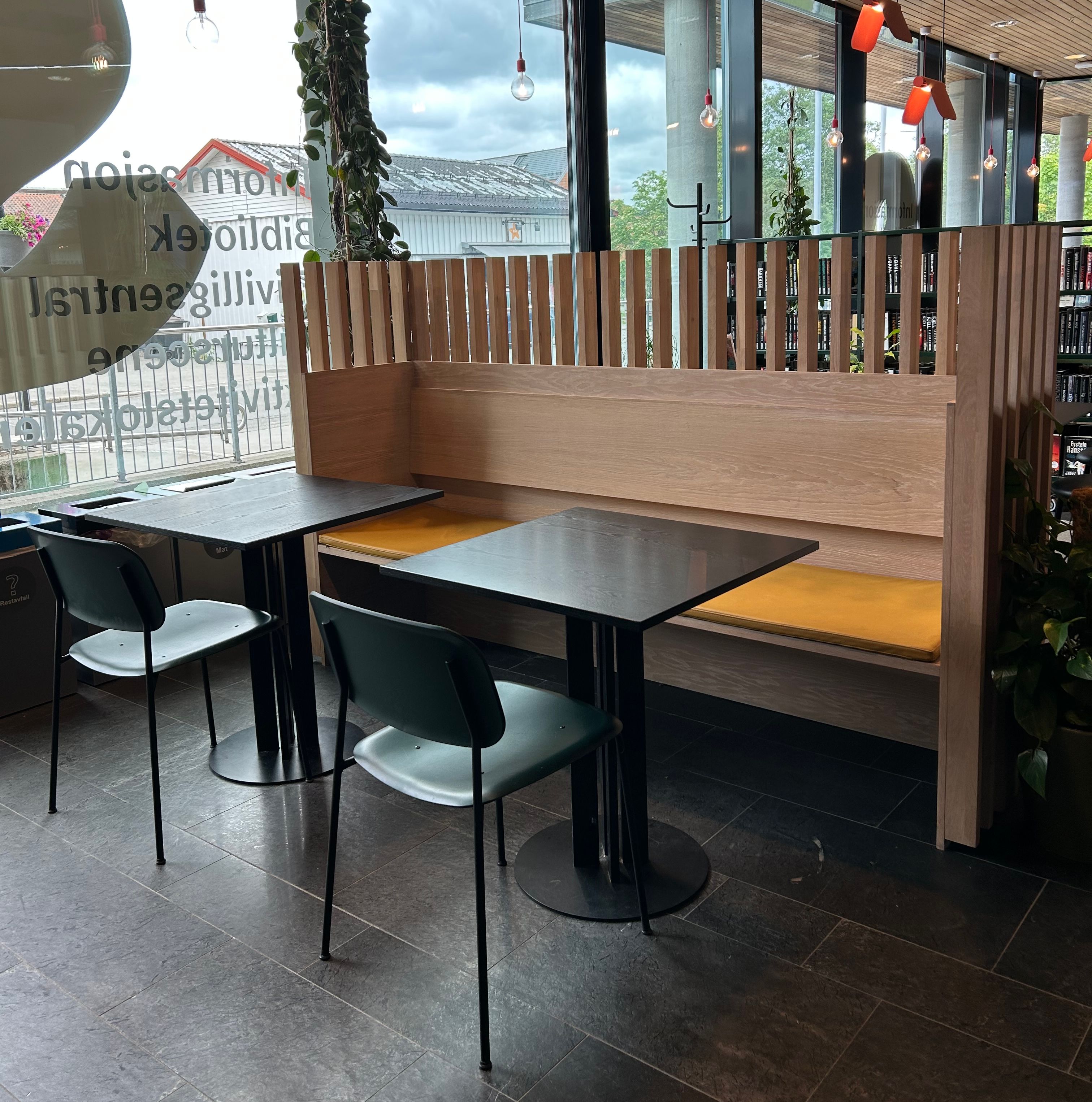 sitteplasser i et bibliotek med en bakvegg med spiler øverst