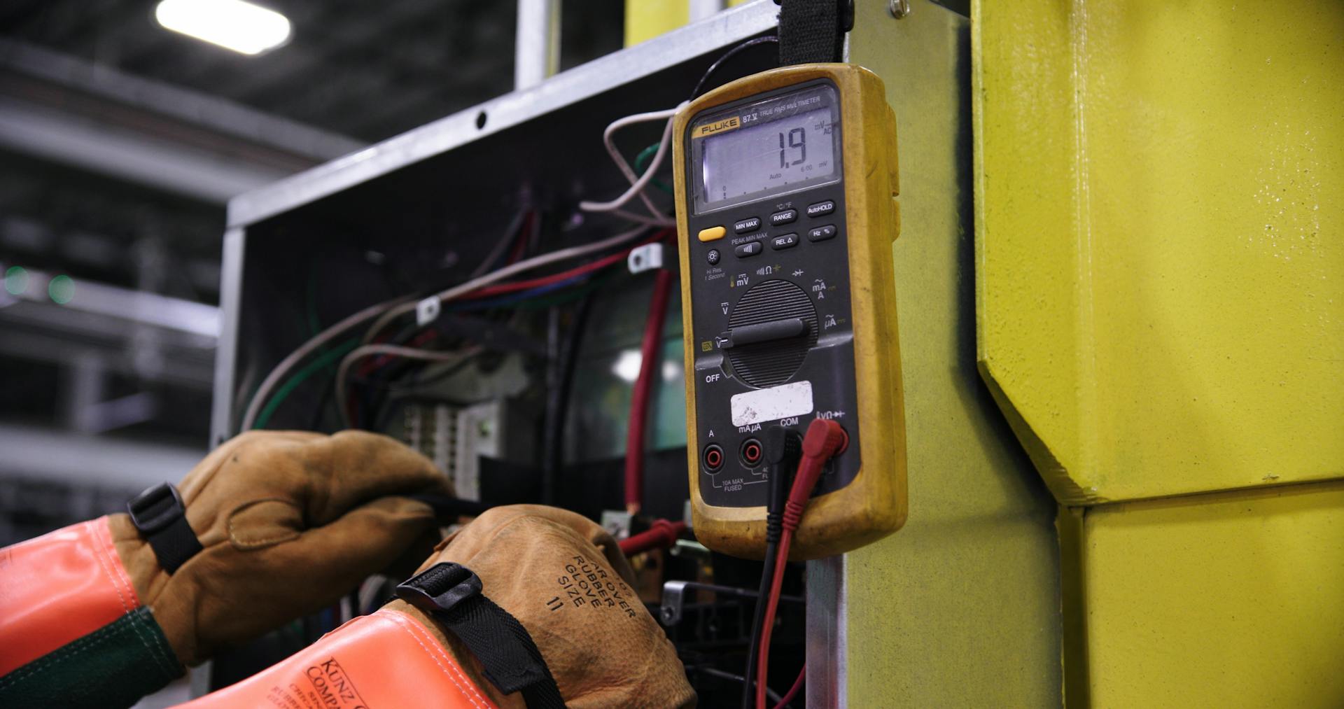 Technicien avec multimètre sur installation