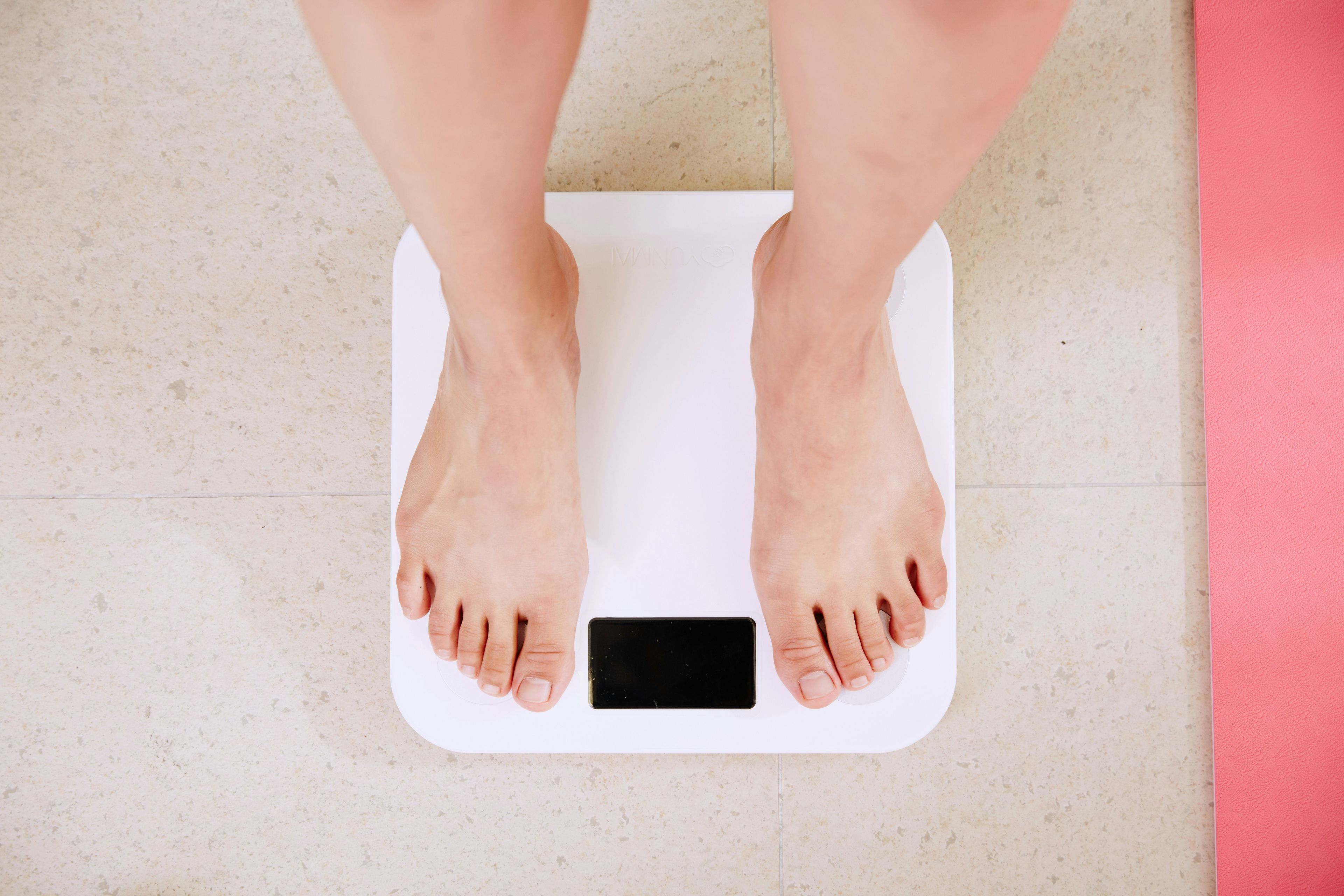 a person is standing on a scale with her feet on it .