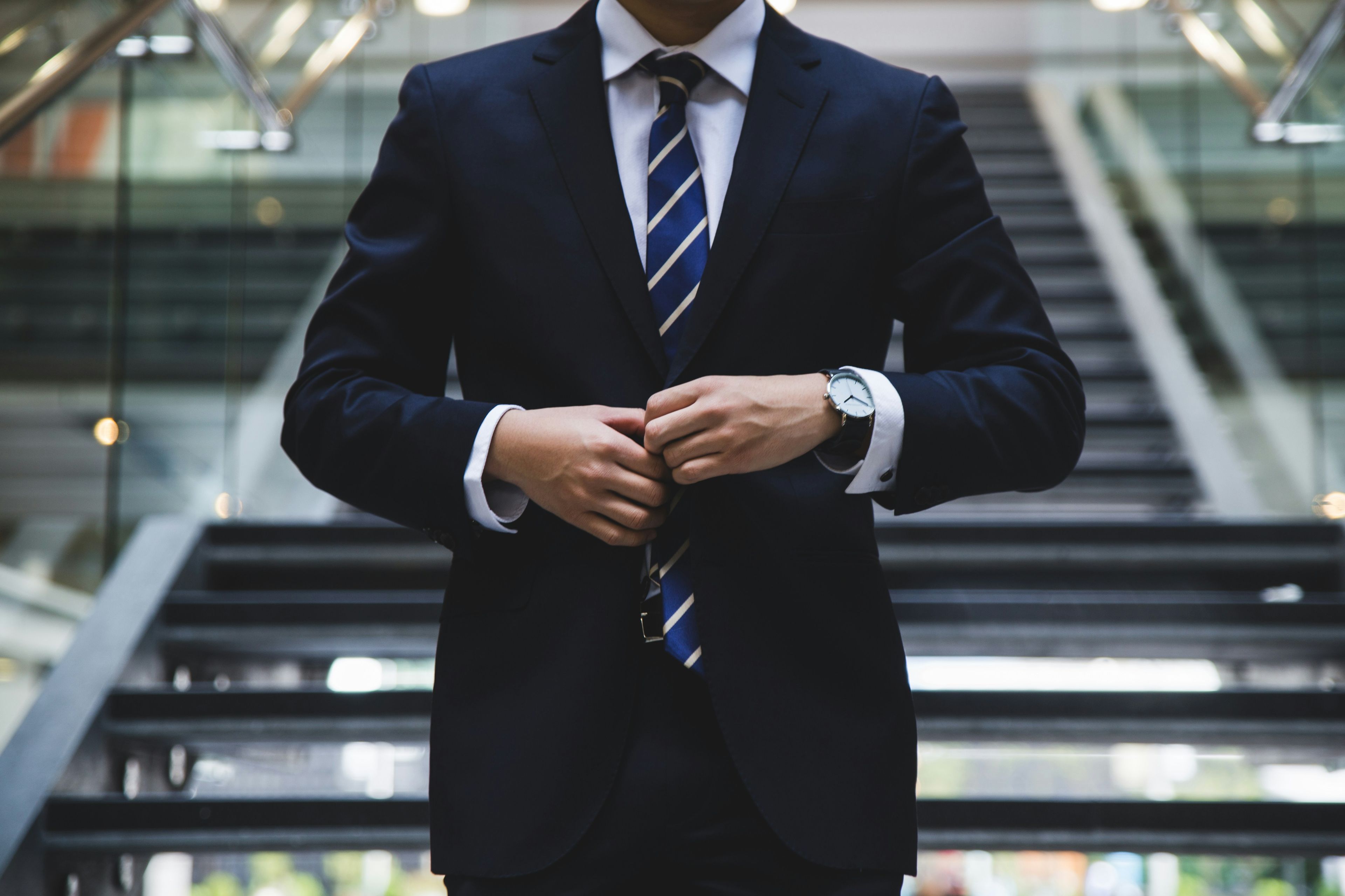 a man in a suit and tie is standing on a set of stairs .