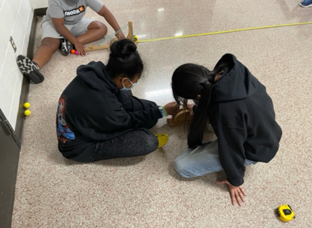 Students running designed experiments with trebuchets.