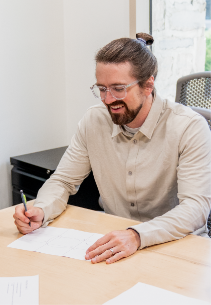 A participant smiling while sketching a pig outline from written instructions