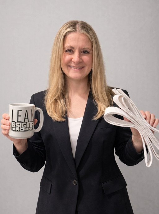 A Veritext employee holding her white belt and a 'Lean 6 Sigma Machine' Coffee Mug